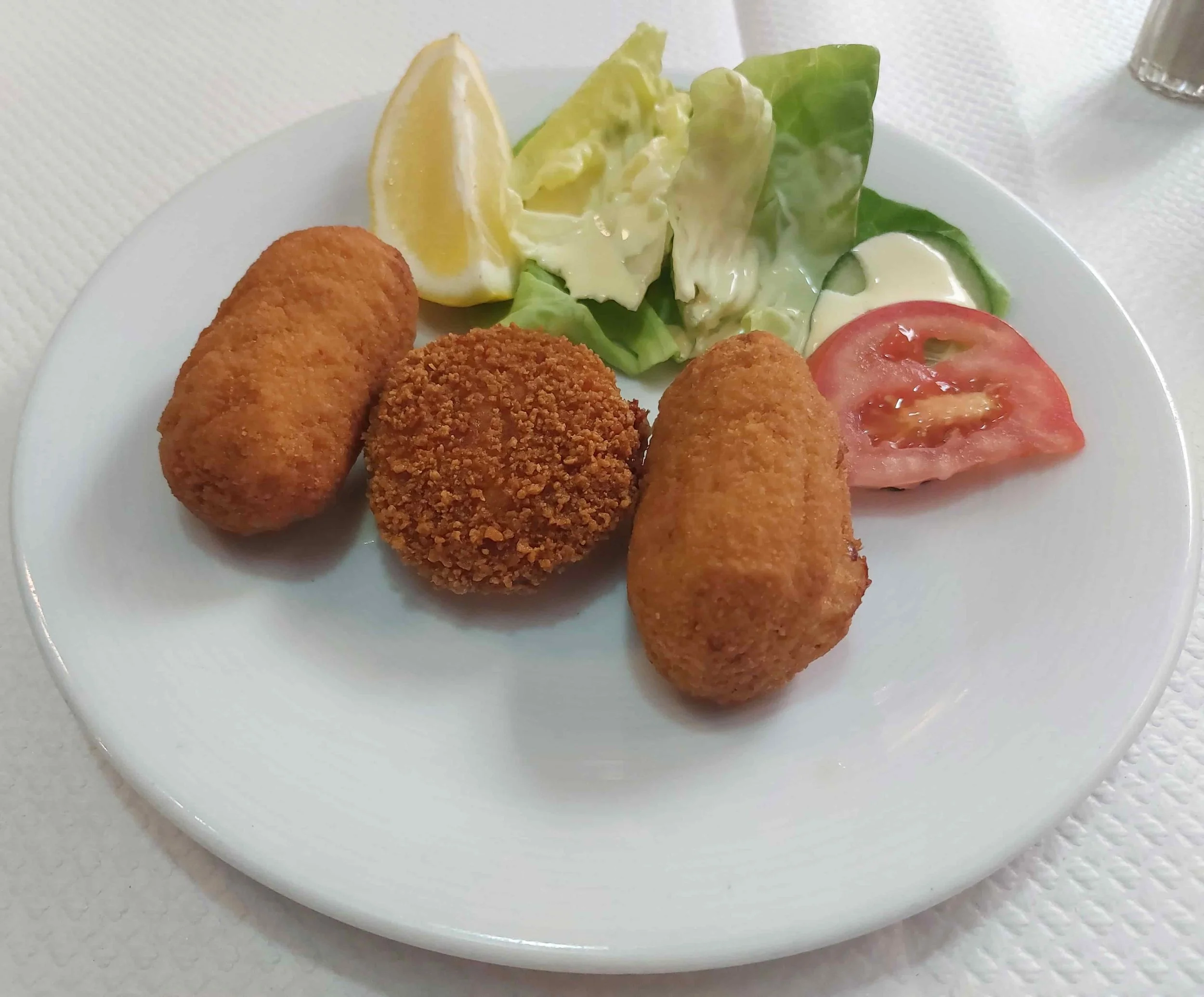 Belgian croquettes two shrimp and one cheese with tomato, lettuce, lemon, and mayonnaise