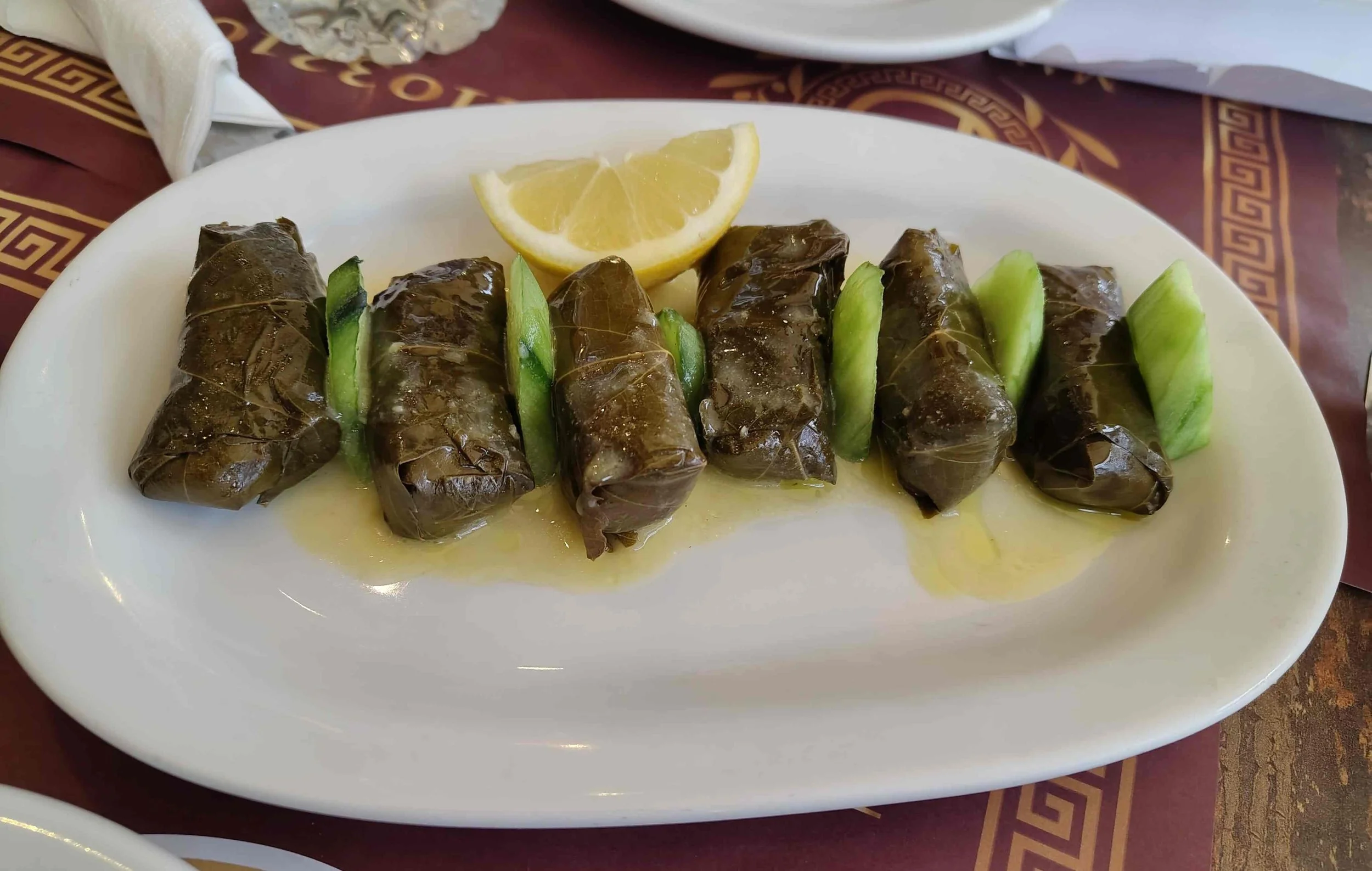 Dolmades – Greek vine leaves stuffed with rice and herbs, served with a lemon wedge