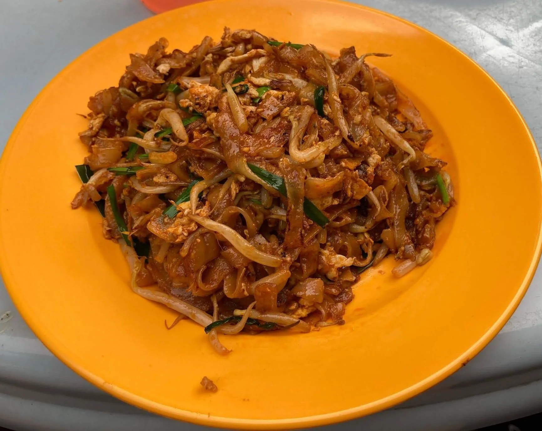 Char Kway Teow stir-fried flat rice noodles with bean sprouts, and egg
