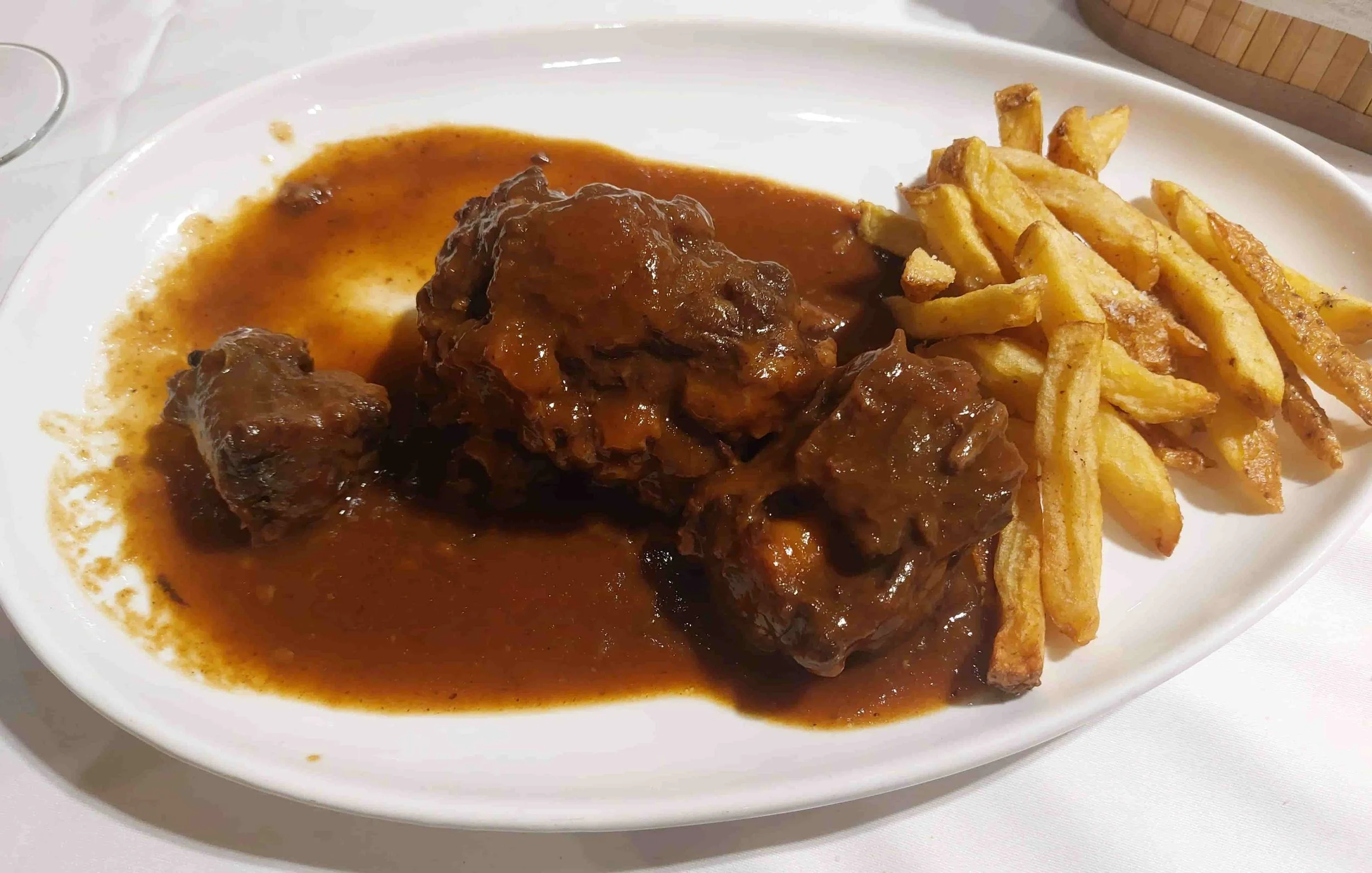 Spanish rabo de toro slow-braised oxtail stew served with crispy fries