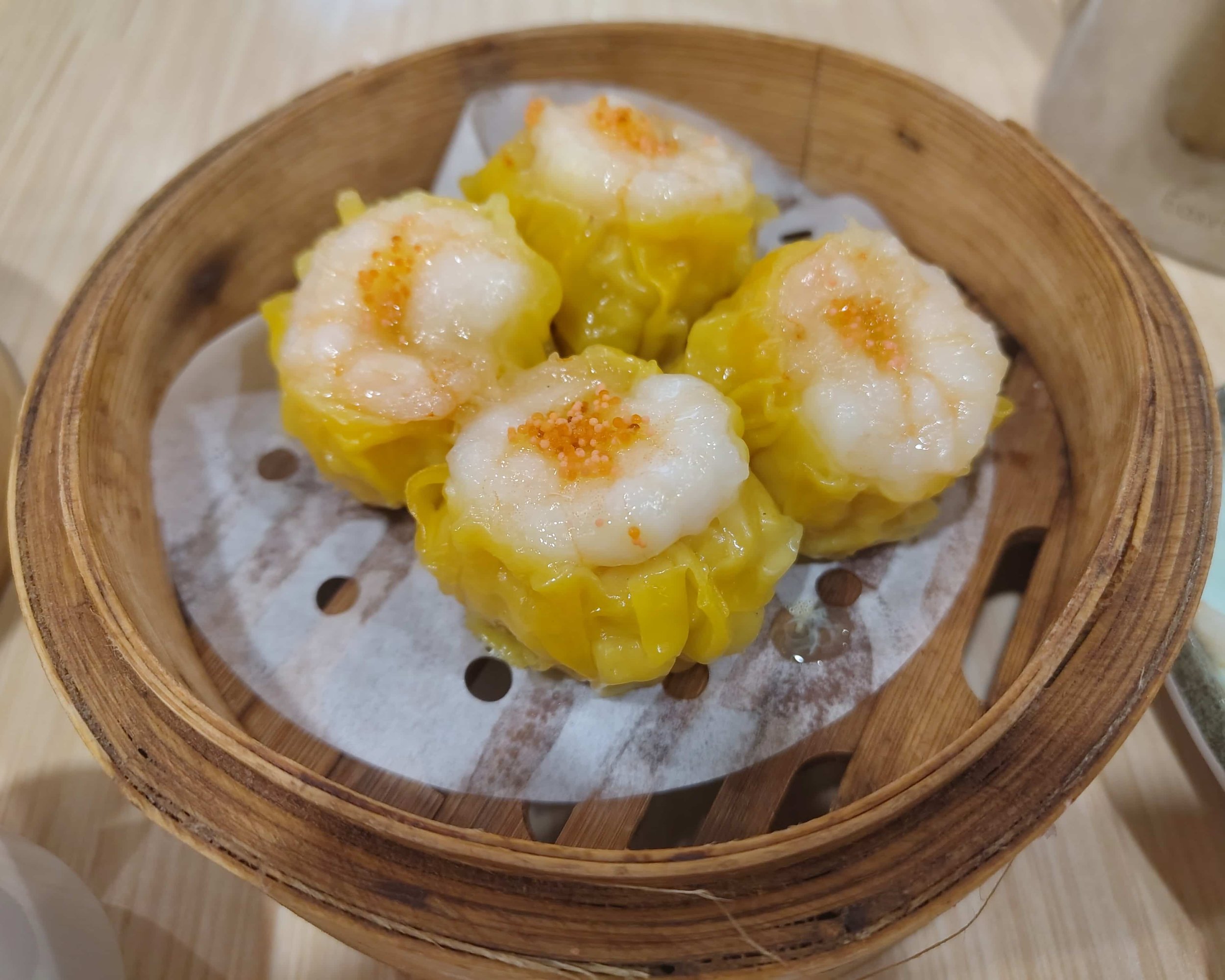 Siu mai – four Hong Kong-style pork and prawn dumplings served in a bamboo steamer