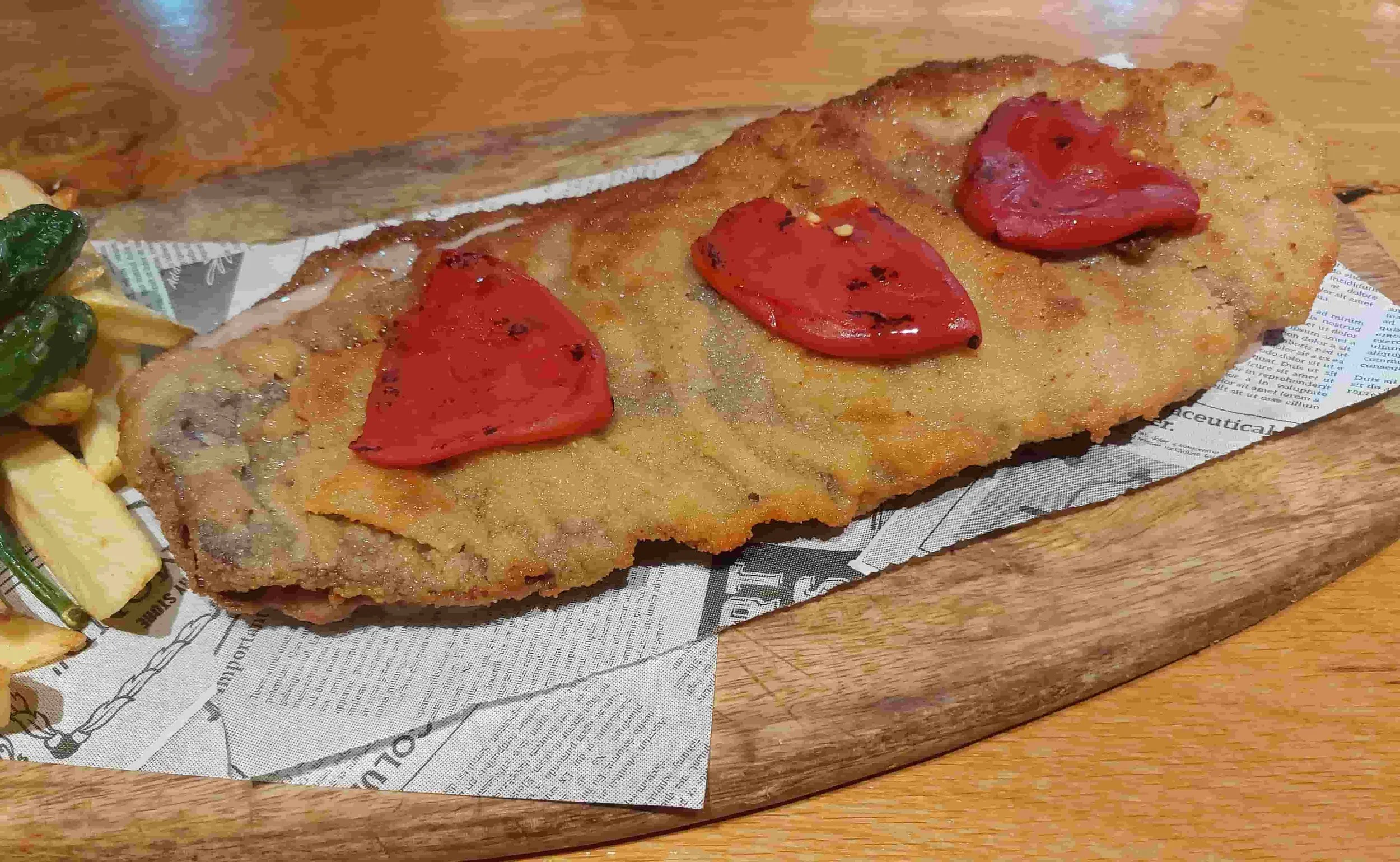Spanish Cachopo breaded veal stuffed with cheese and ham, topped with peppers