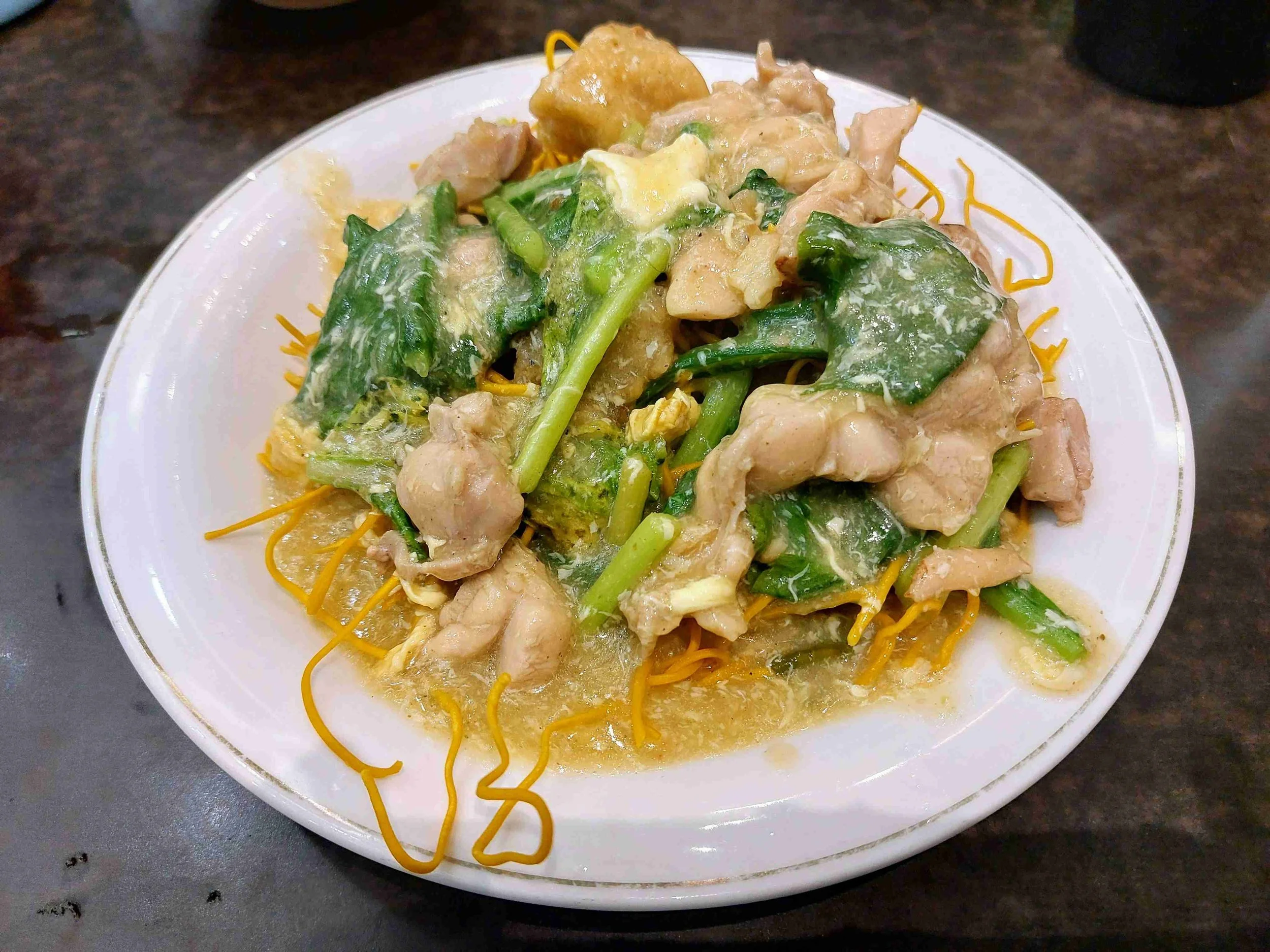 Mie Titi, crunchy fried noodle dish with shredded chicken and fresh greens