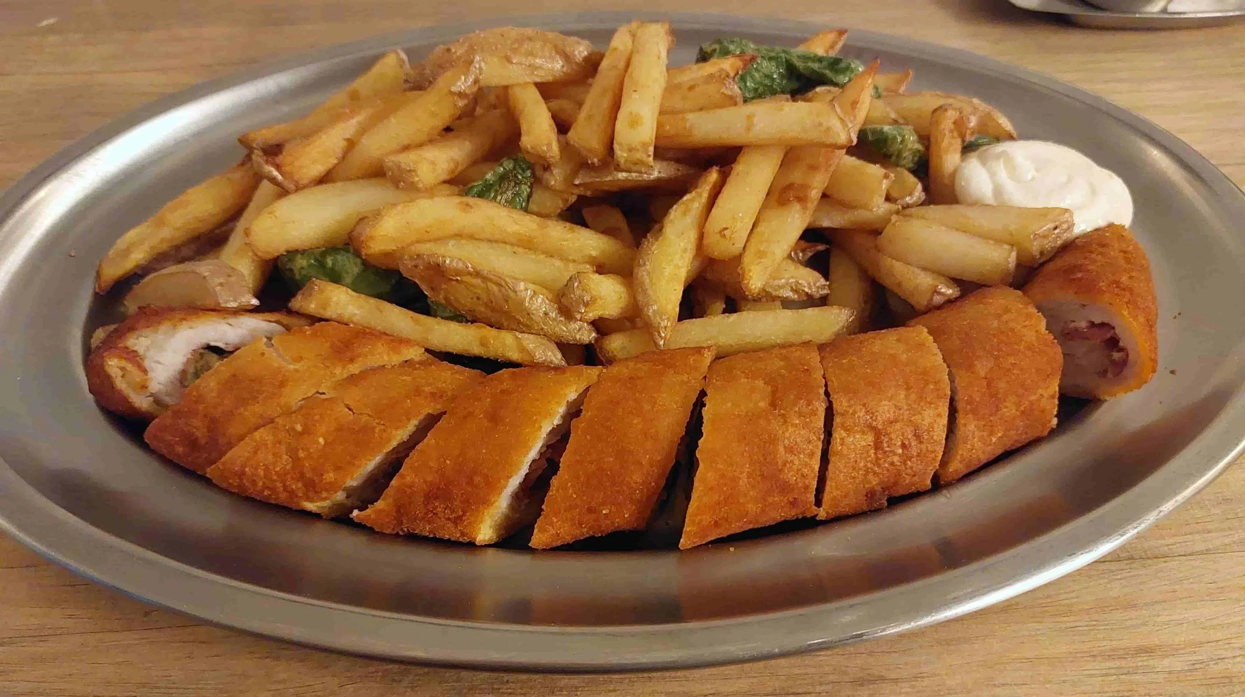 Spanish Flamenquín breaded pork roll served with fries and Padrón peppers