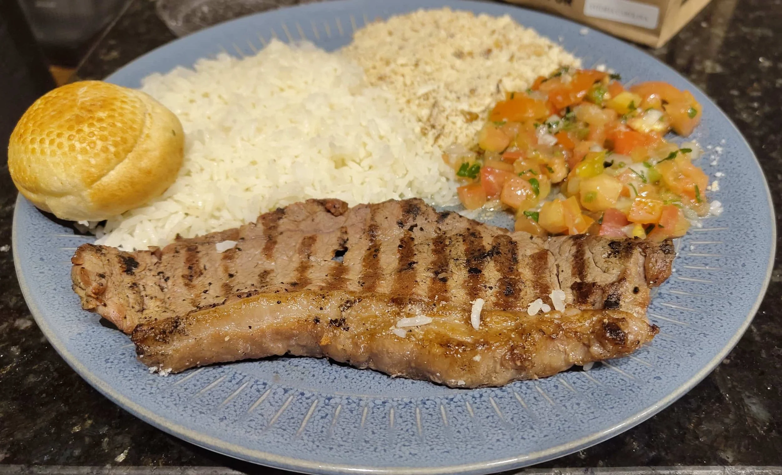 Traditional Brazilian churrasco with grilled meat served alongside rice, farofa and traditional accompaniments