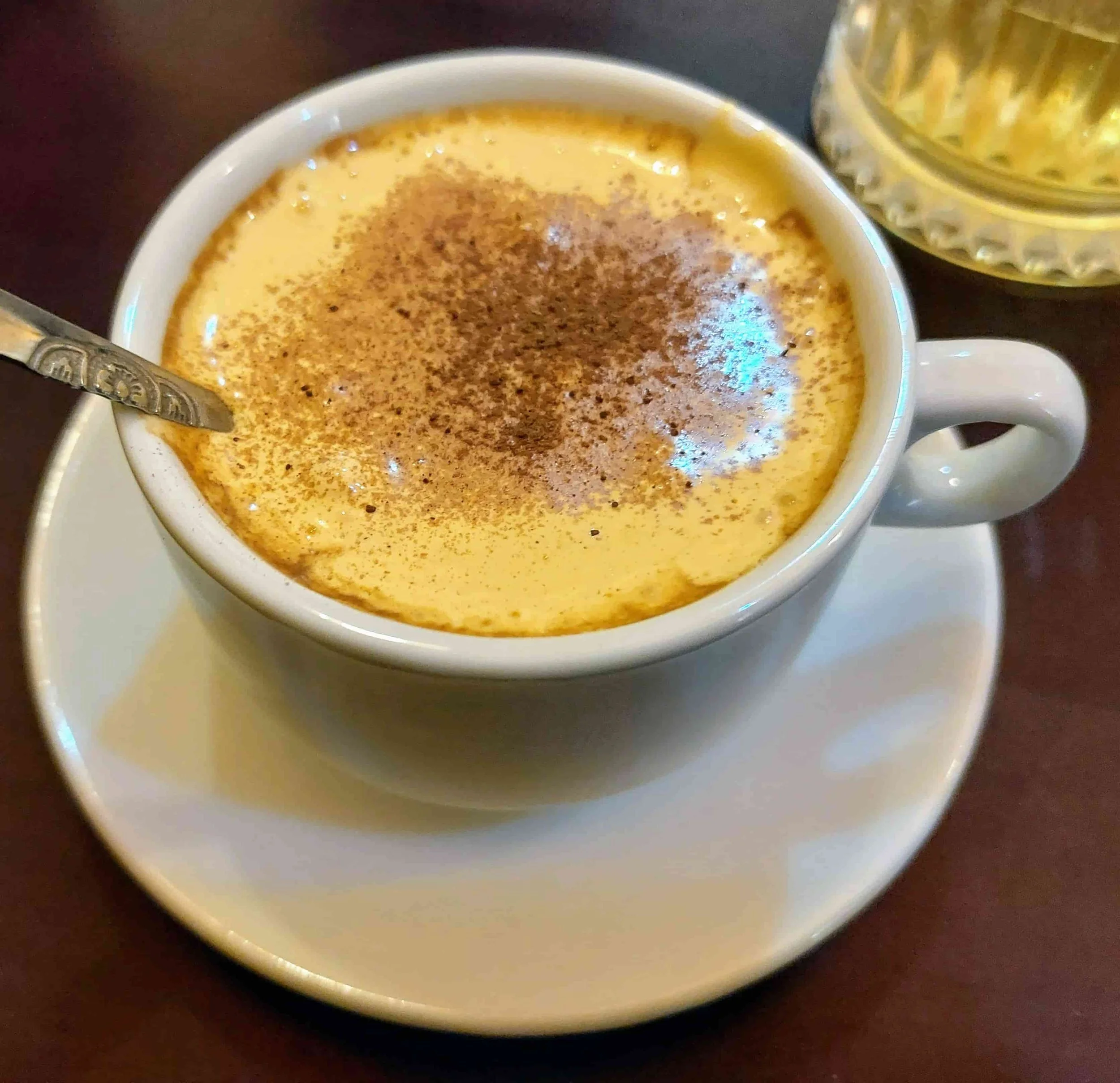 Cà Phê Trứng Vietnamese egg coffee featuring frothy whipped egg yolk cream over hot coffee