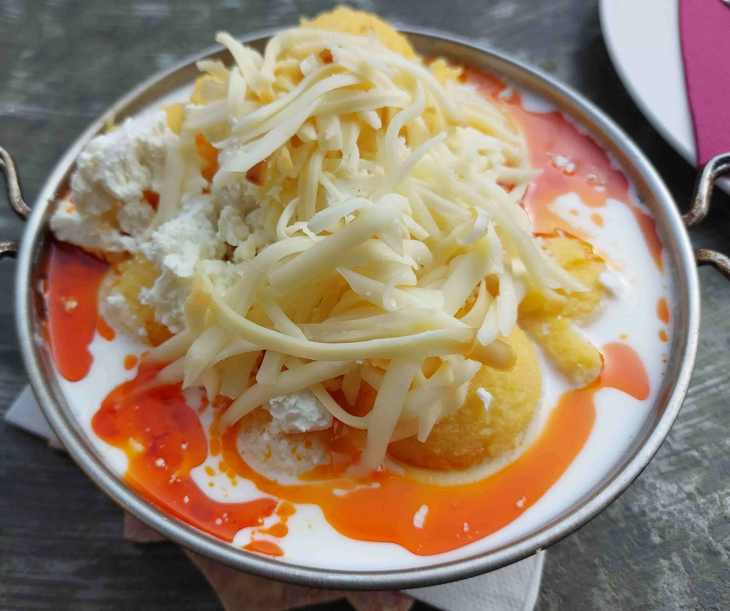 Traditional Bosnian pura served as polenta balls with creamy cheese