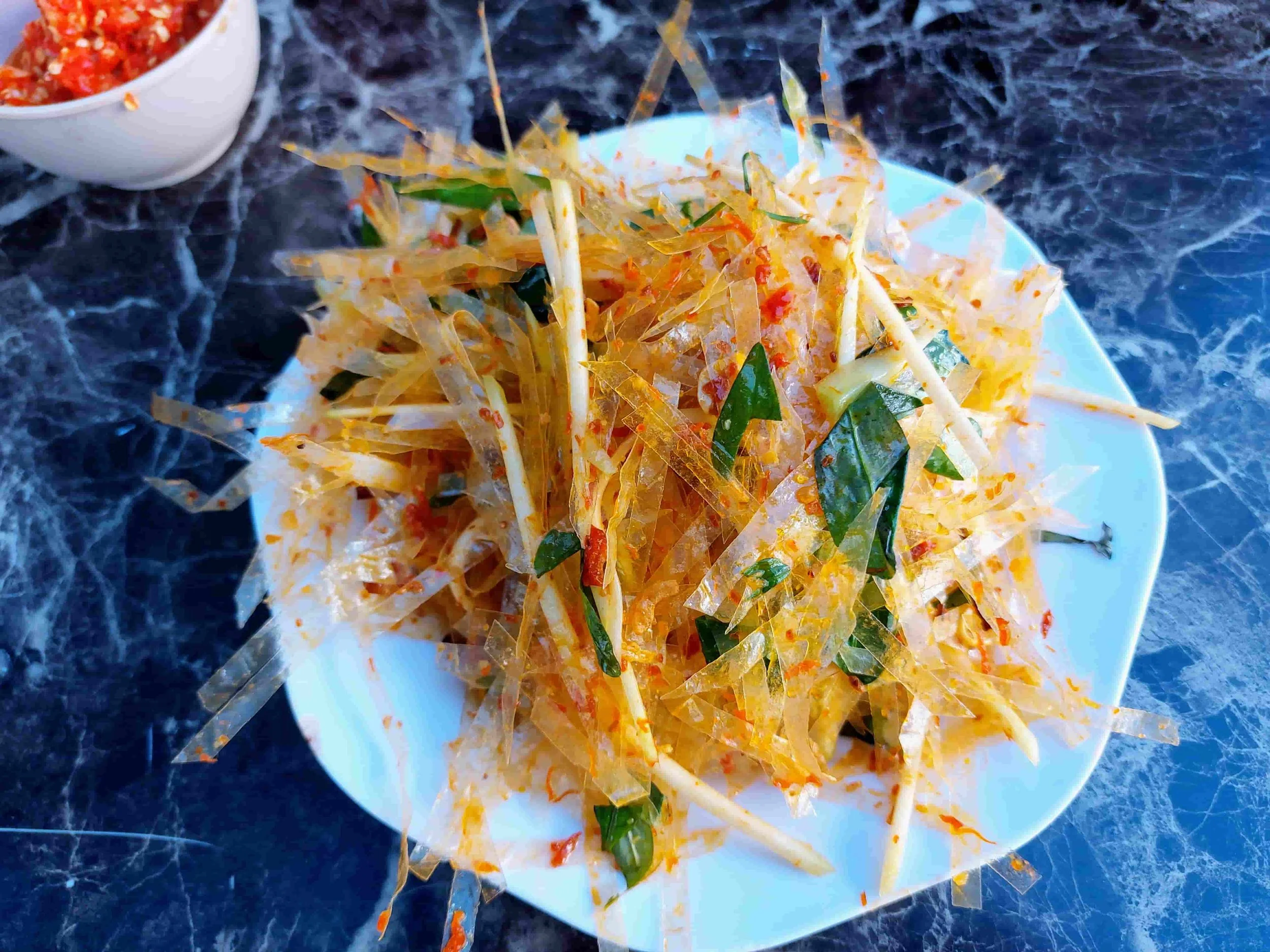 Bánh Tráng Trộn – Vietnamese mixed rice paper salad with shredded dried shrimp, herbs, peanuts, chili, and lime.