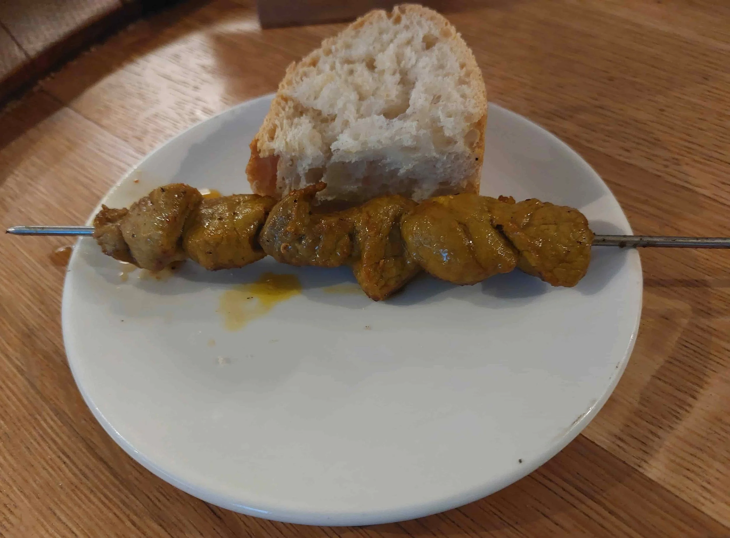 Spanish pinchos morunos spiced grilled meat skewers served with bread