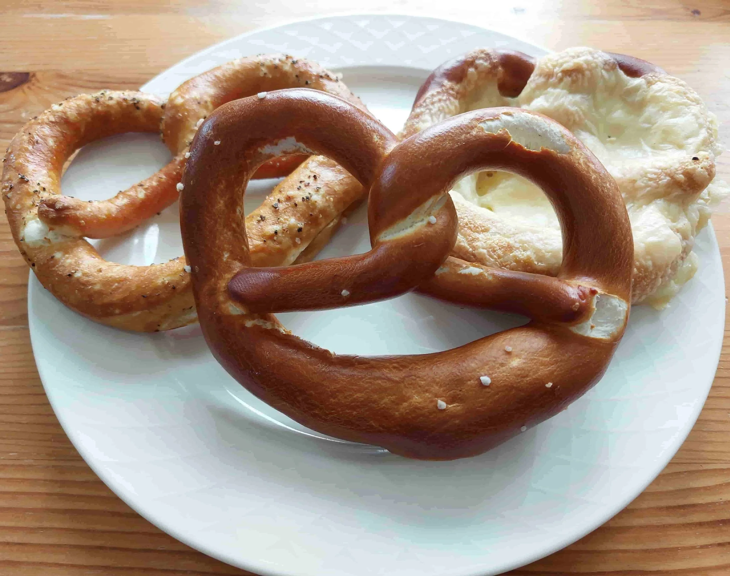 Three German pretzels traditional baked bread, one plain, one with pepper, one with cheese