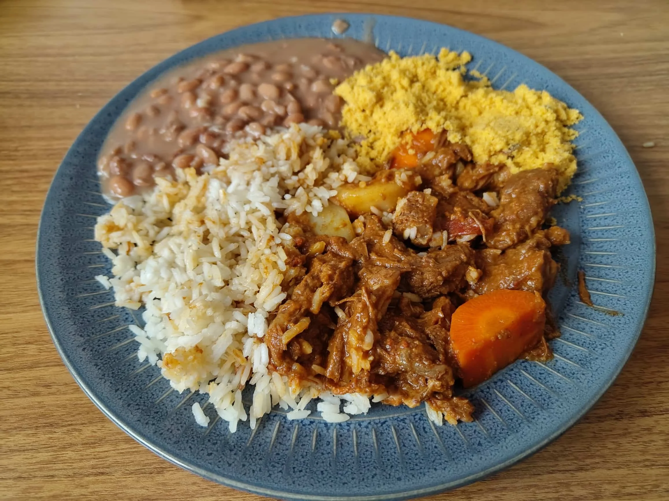 Traditional Brazilian picadinho, diced beef cooked in a savoury sauce and served with rice and traditional accompaniments