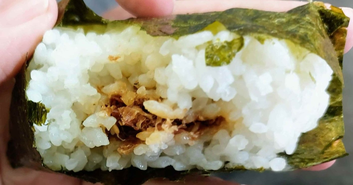 Japanese onigiri – triangular rice ball wrapped in nori seaweed, filled with savoury ingredients like tuna mayo or pickled plum.