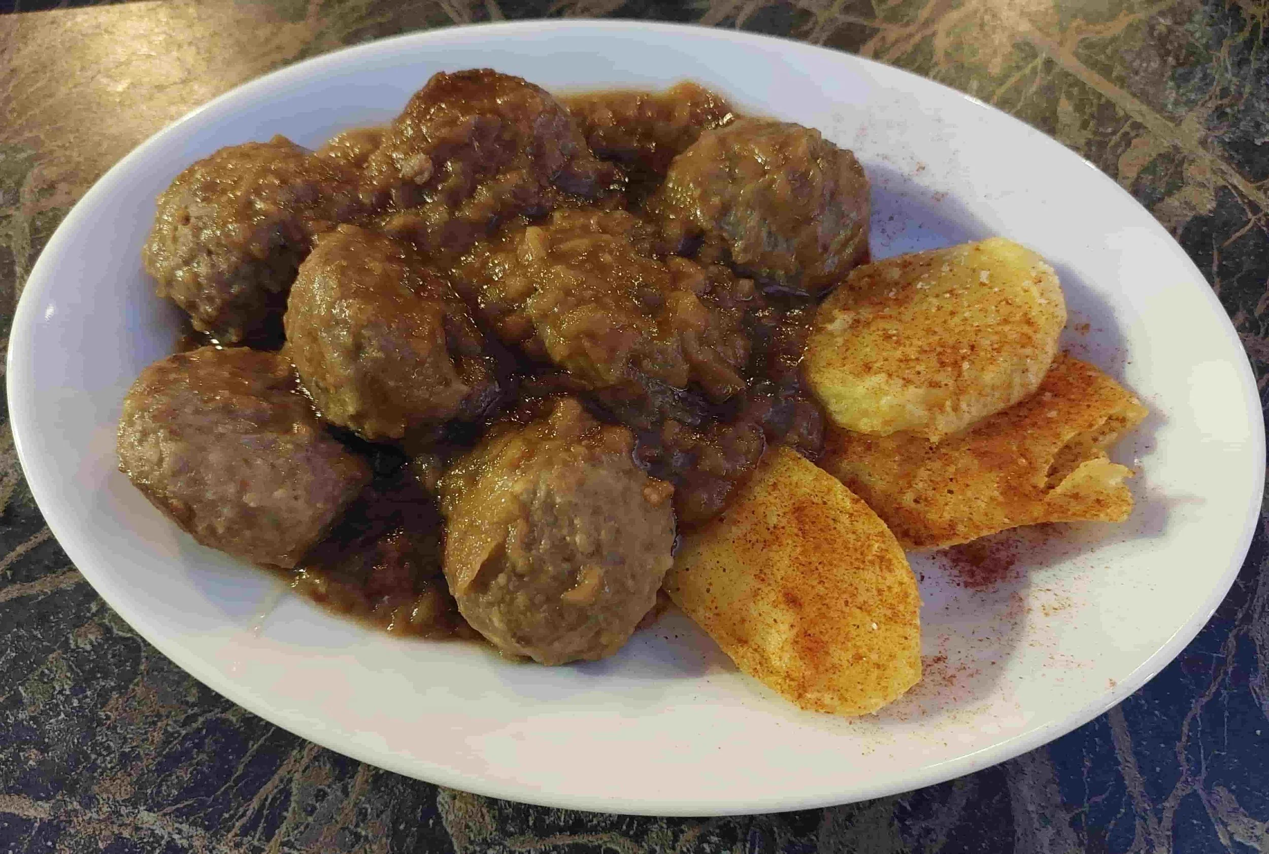 Spanish albóndigas meatballs in brown sauce served with potato crisps