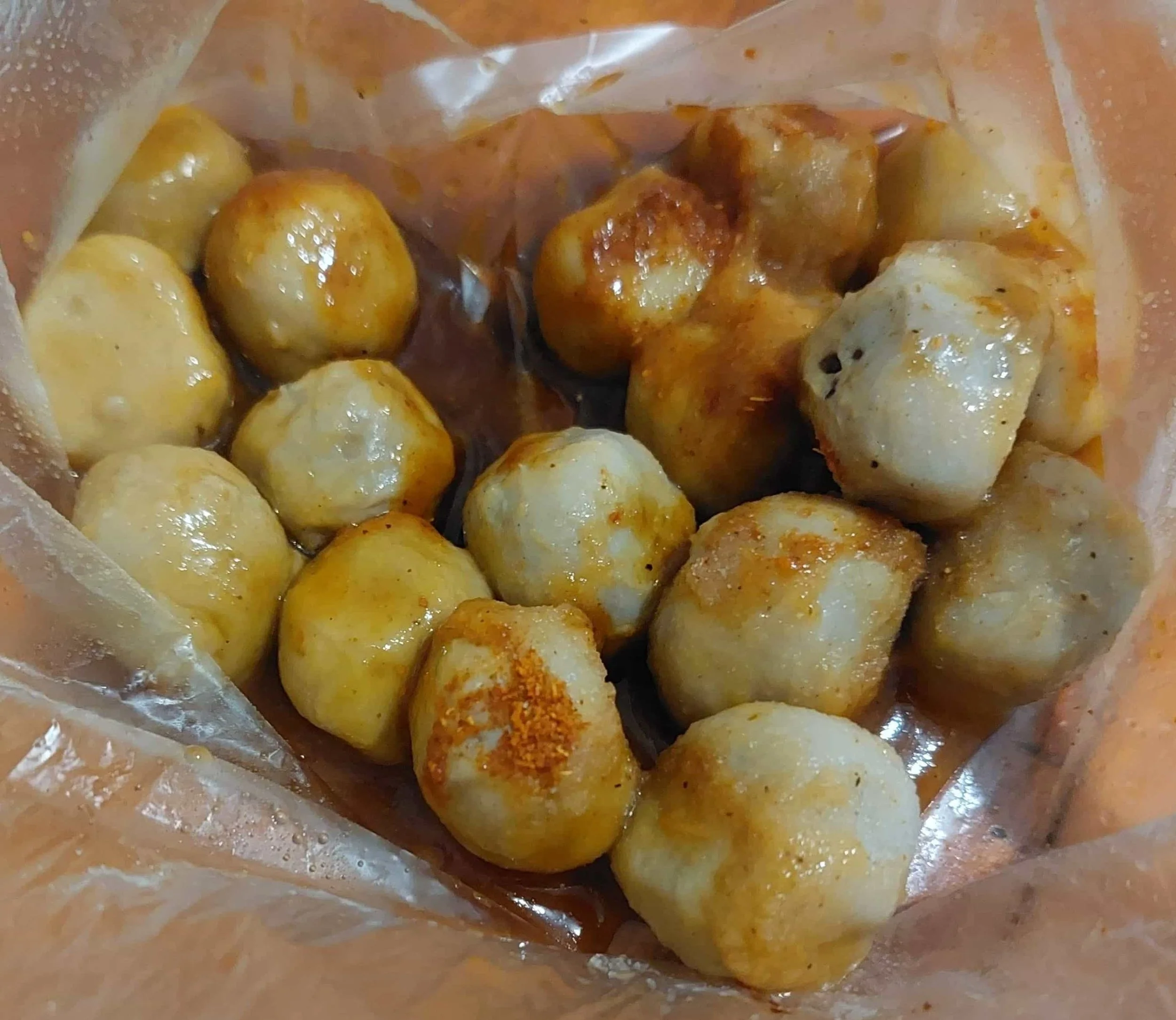 Chewy cilok snacks topped with rich soy-based dipping sauce