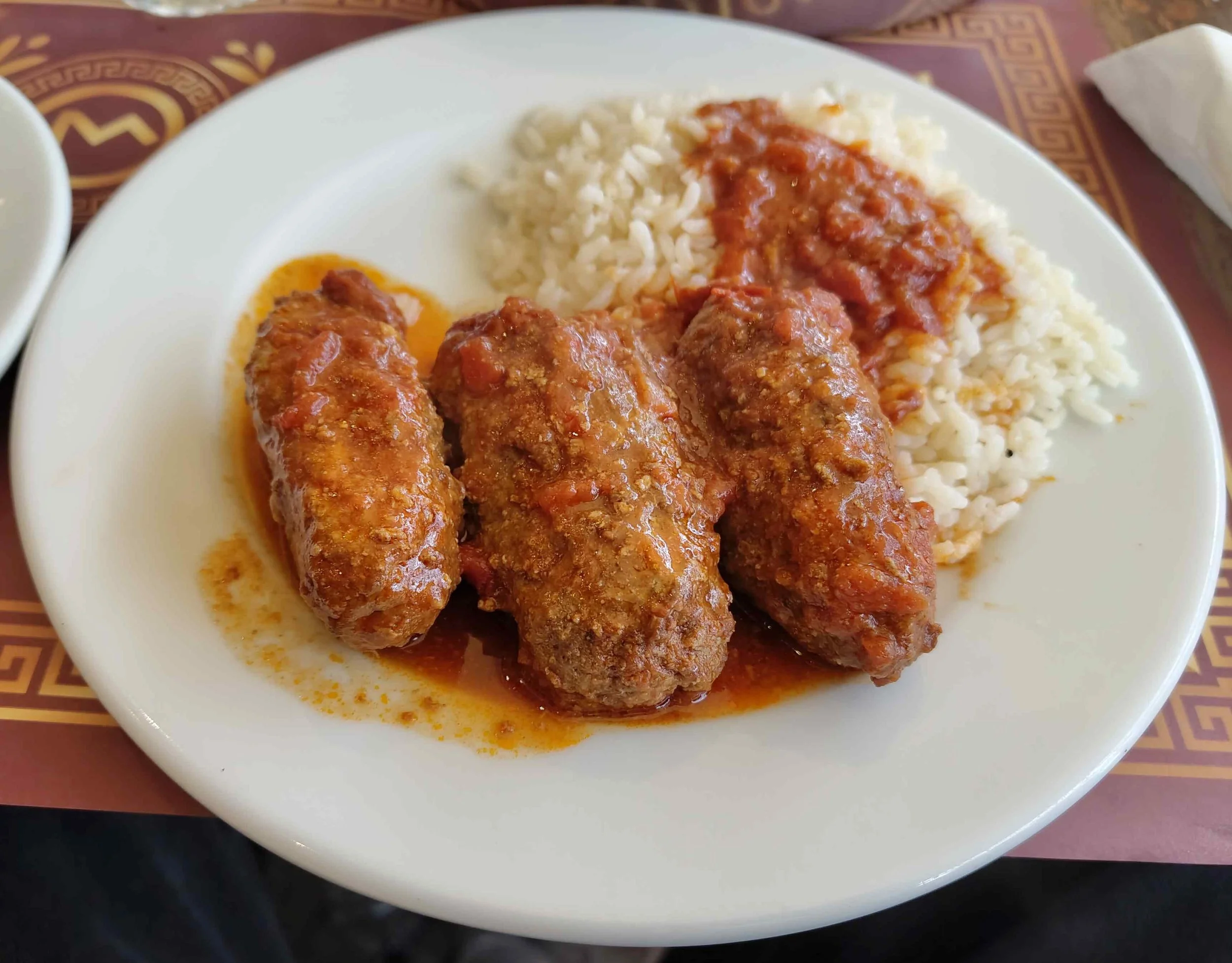 Soutzoukakia – Greek spiced meatballs in tomato sauce served with rice