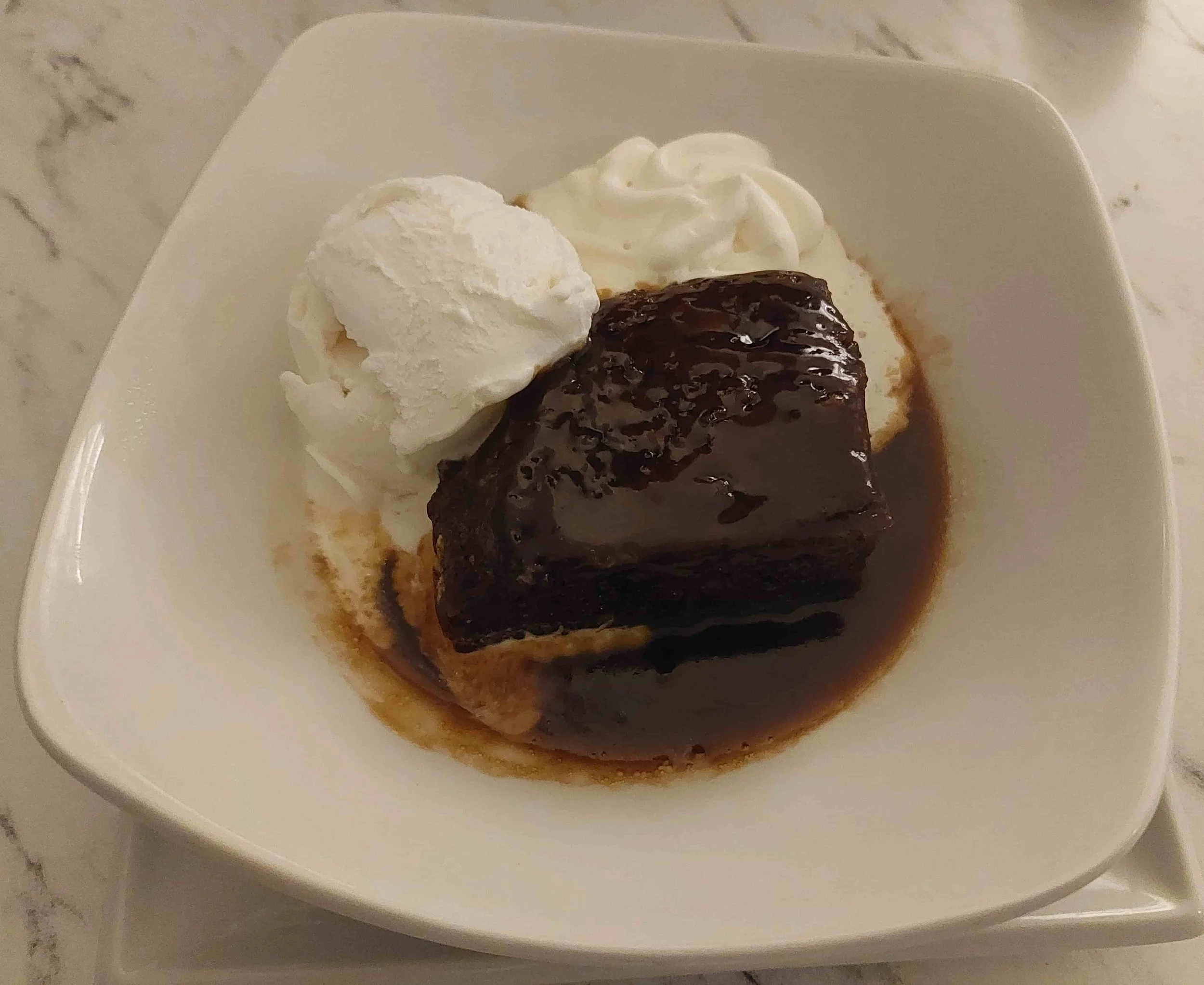 British Sticky Toffee Pudding moist sponge cake with toffee sauce, cream, and ice cream