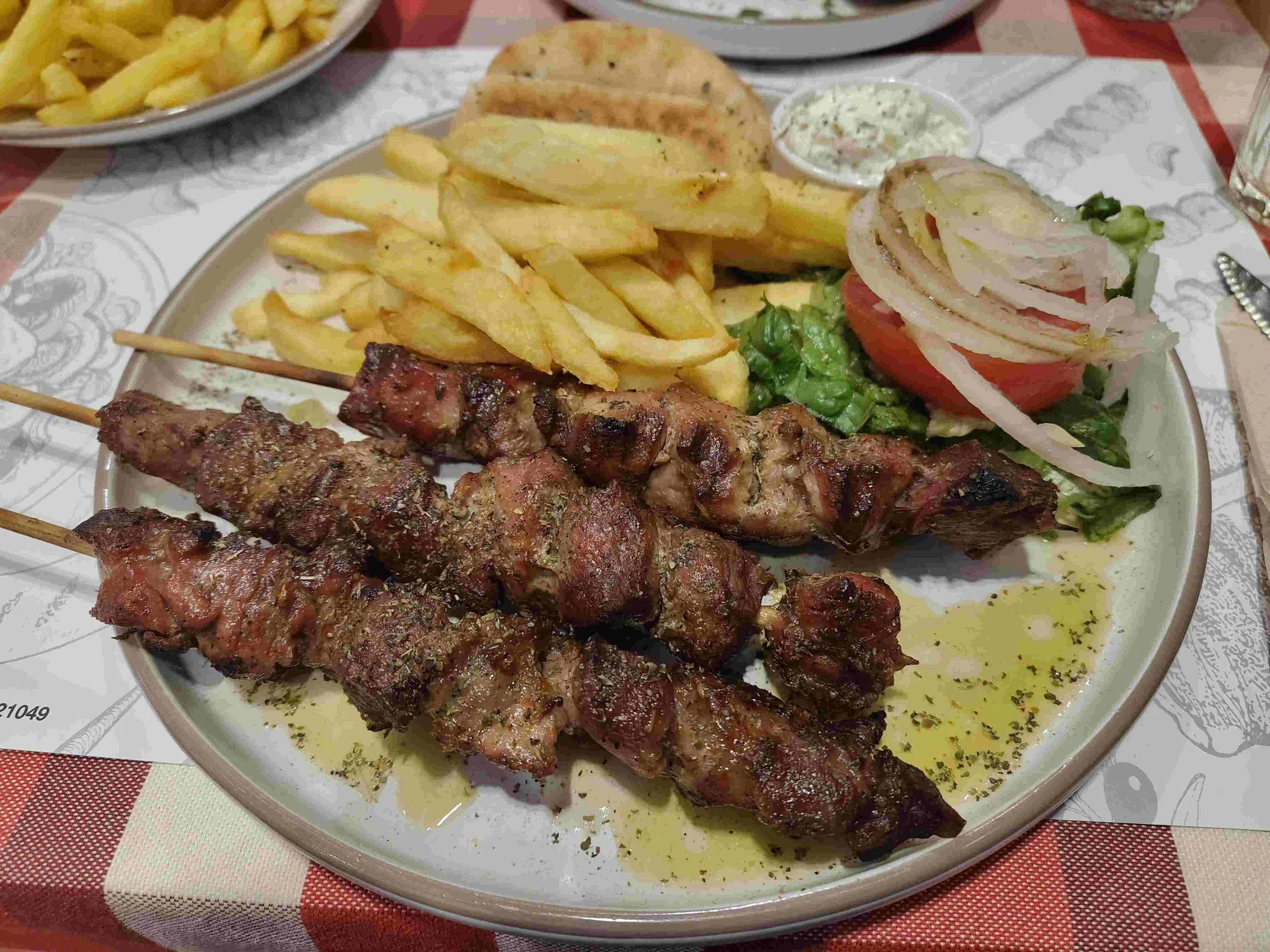Souvlaki – Greek grilled meat skewers served with pita bread, fries, and salad
