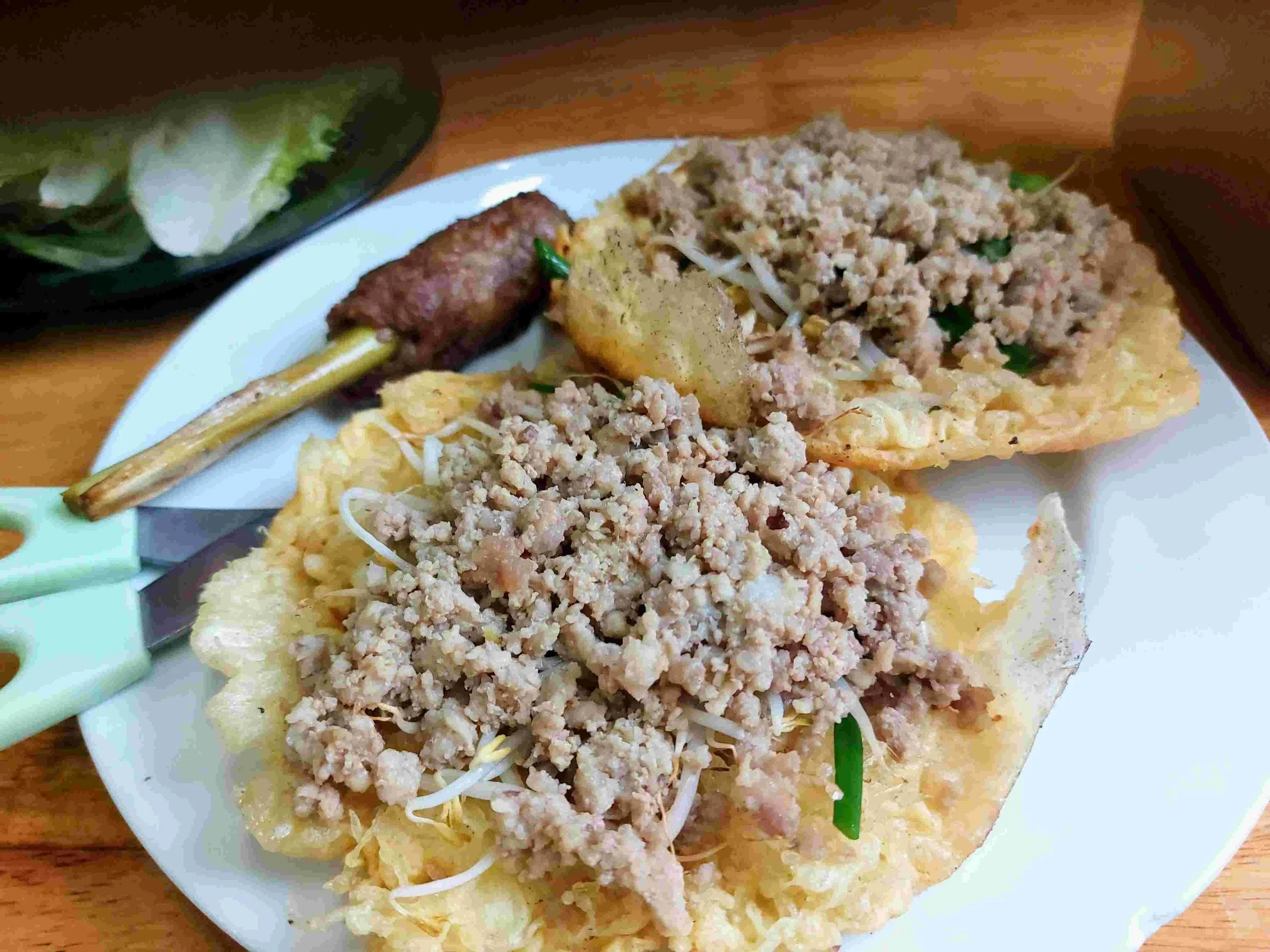 Bánh Xèo – Vietnamese crispy savory pancake filled with minced pork, shrimp, and bean sprouts, served with fresh herbs and Nem Lụi
