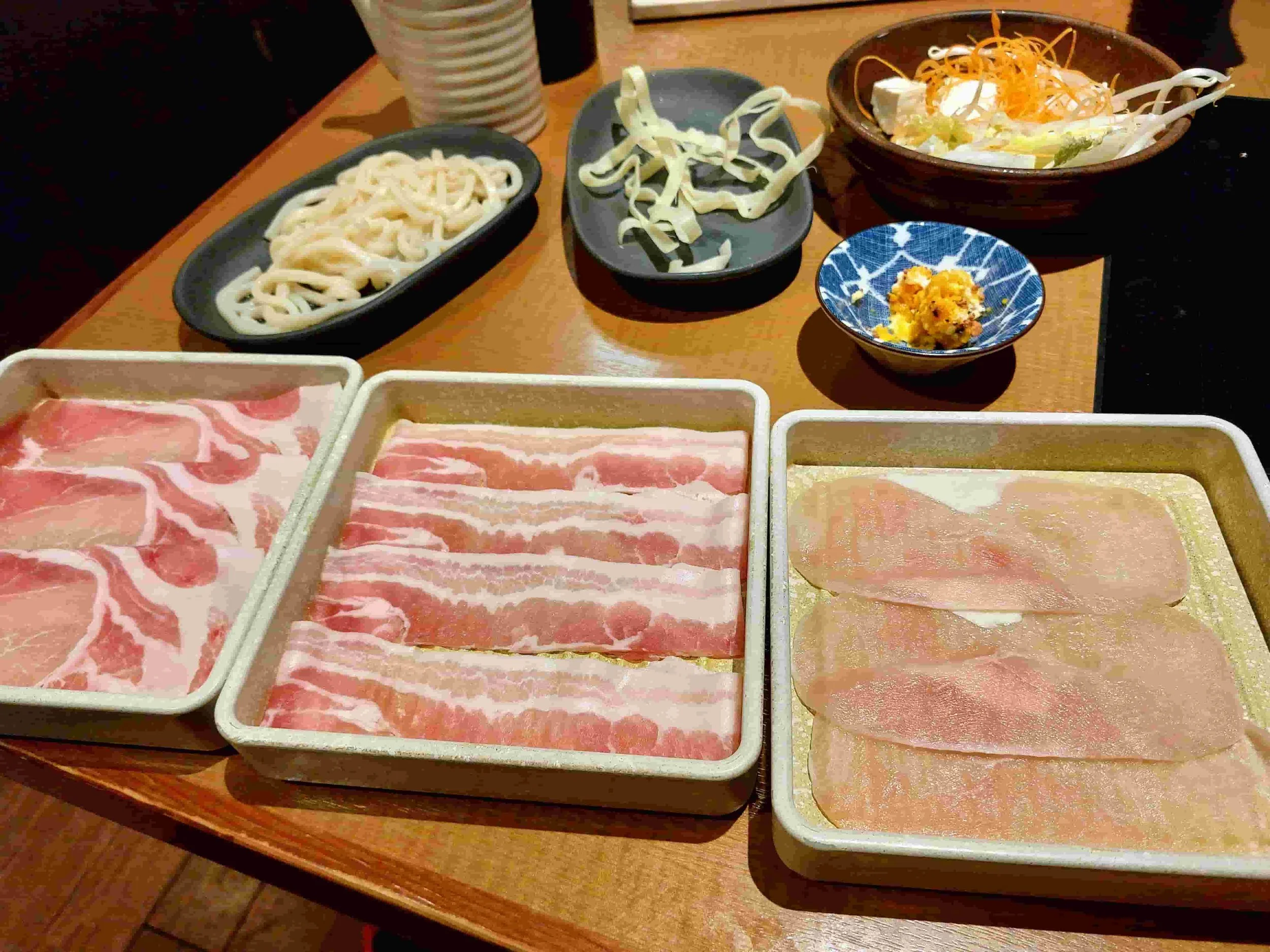 Thinly sliced meat and fresh noodles prepared for Japanese shabu shabu hot pot