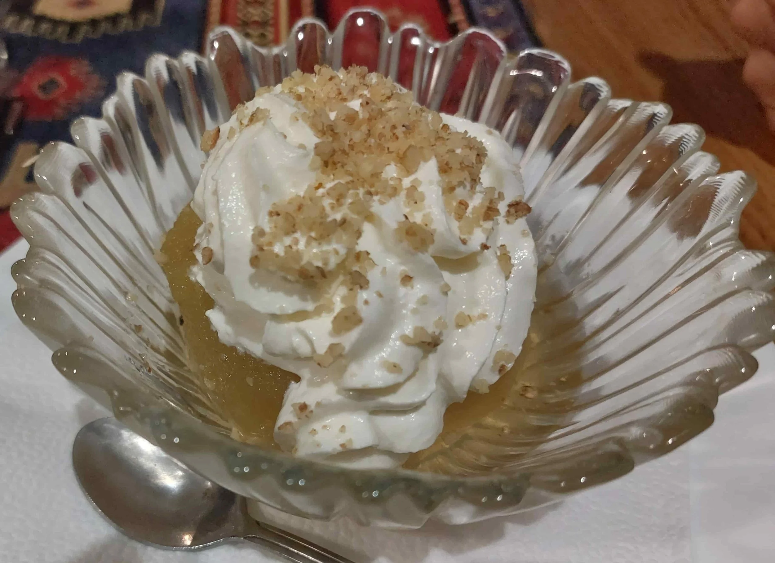 Bosnian tufahija poached apple stuffed with walnut and topped with whipped cream