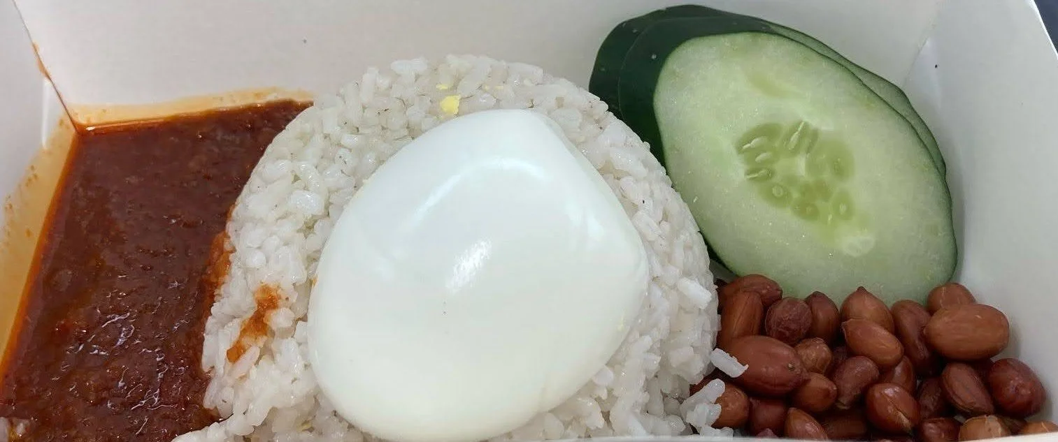 Nasi lemak – Malaysian coconut rice served with sambal, egg, peanuts, anchovies, and cucumber