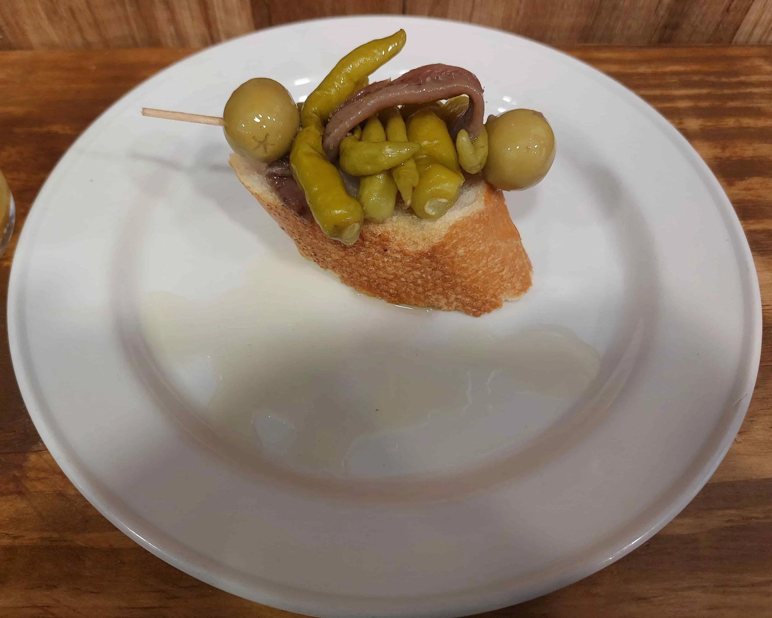 Spanish Gilda pintxo with anchovy, olive, and pepper on bread slice