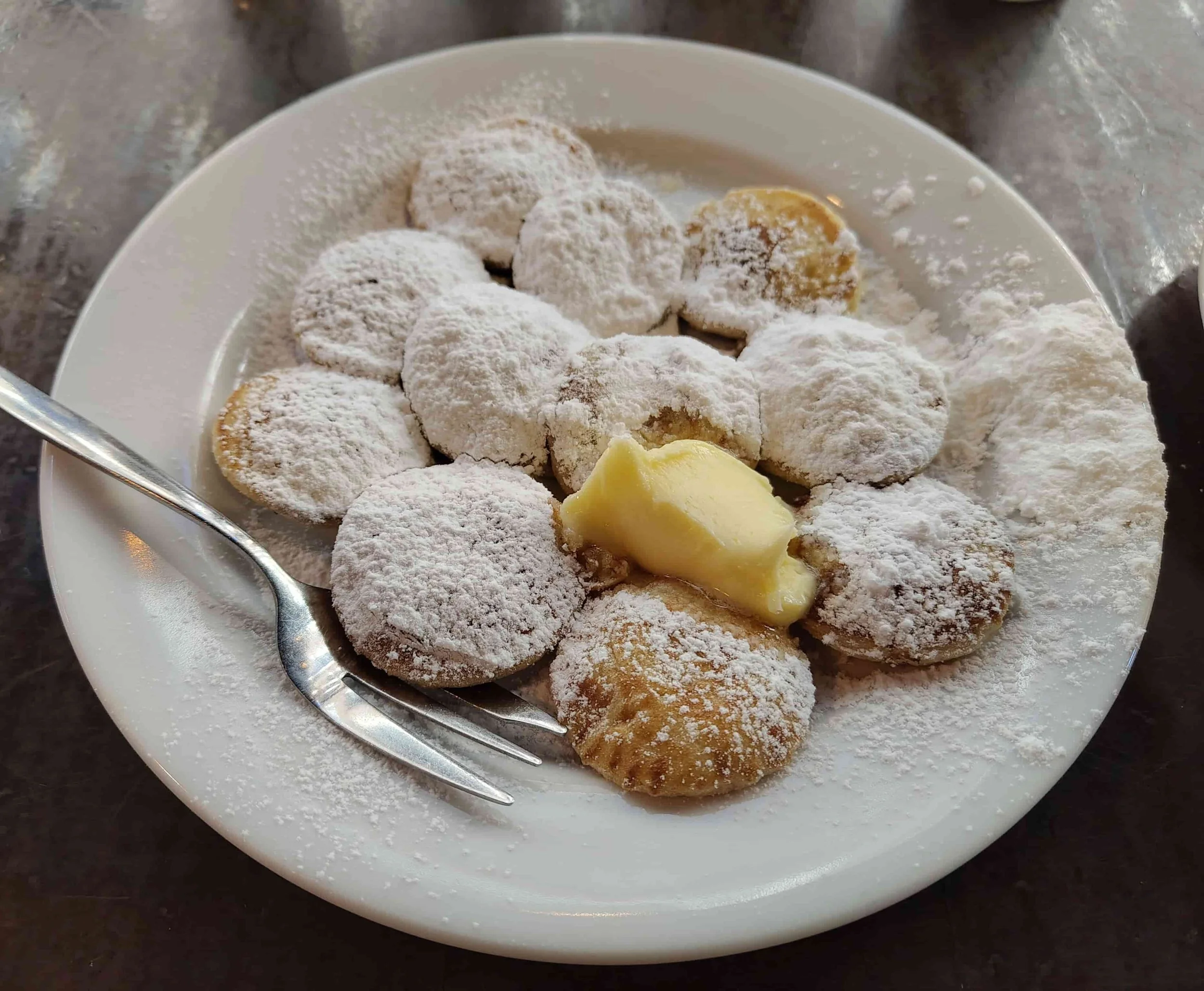 Dutch poffertjes topped with powdered sugar and butter