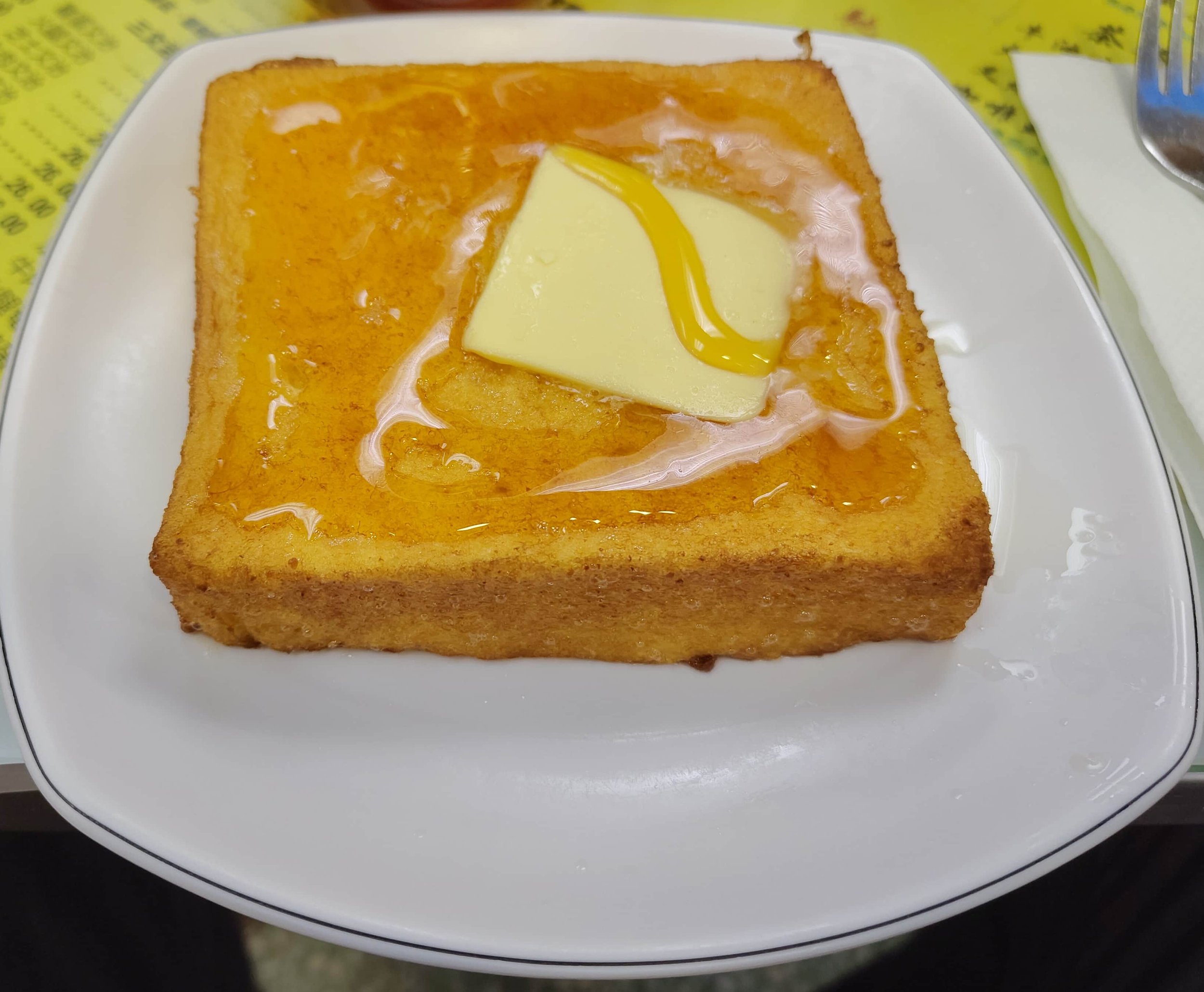 Hong Kong French toast topped with a slab of butter and drizzled with syrup
