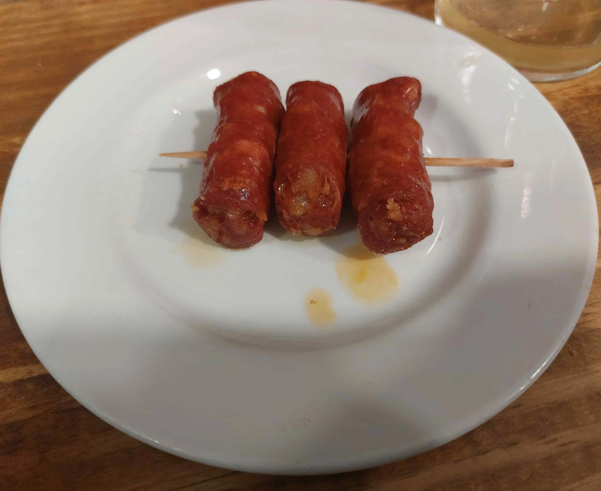 Three Basque txistorra sausages skewered on toothpick served as pintxos