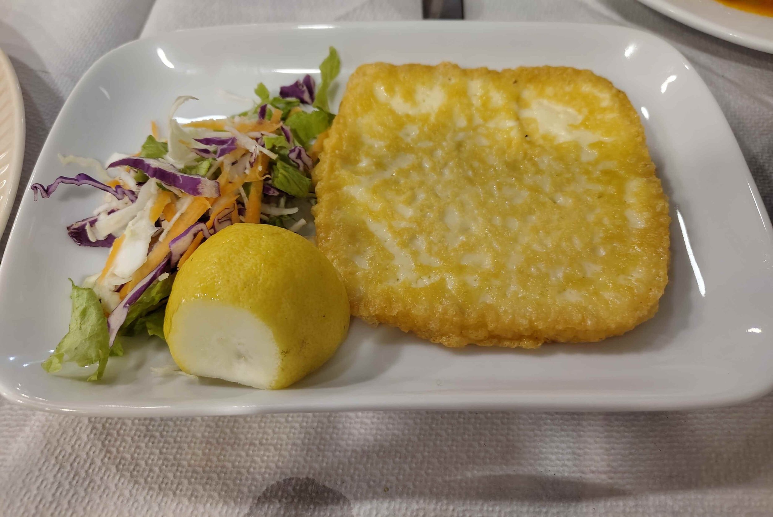 Saganaki – Greek fried cheese served with salad and a wedge of lemon
