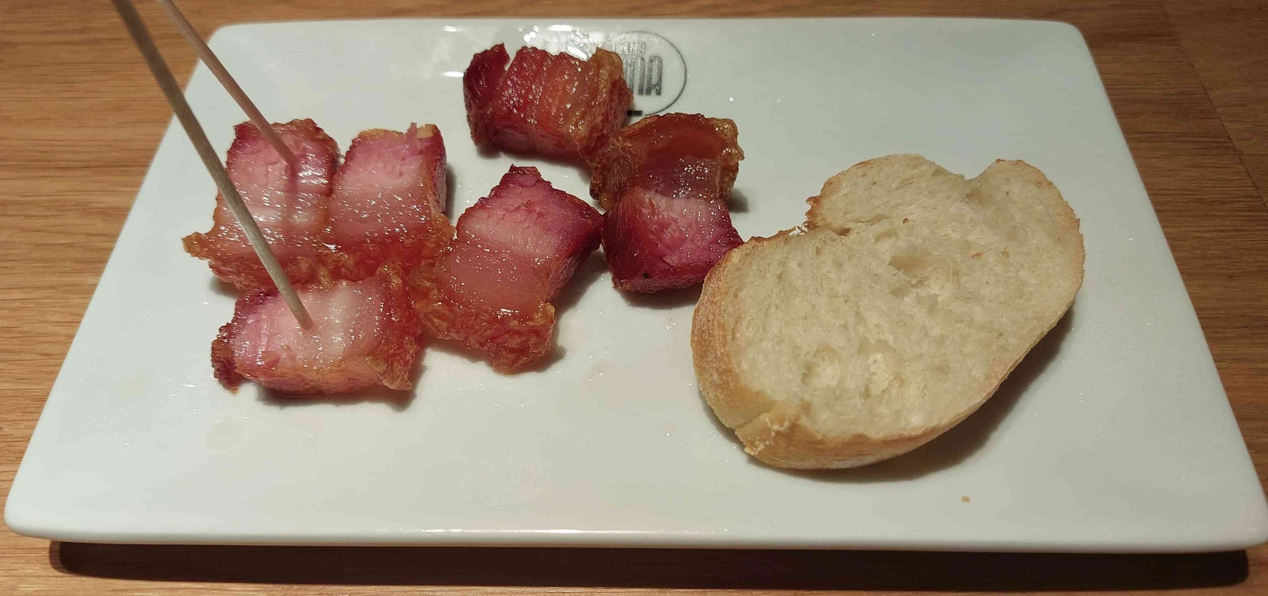 Spanish torrezno pintxos crispy cured pork belly served with bread slice