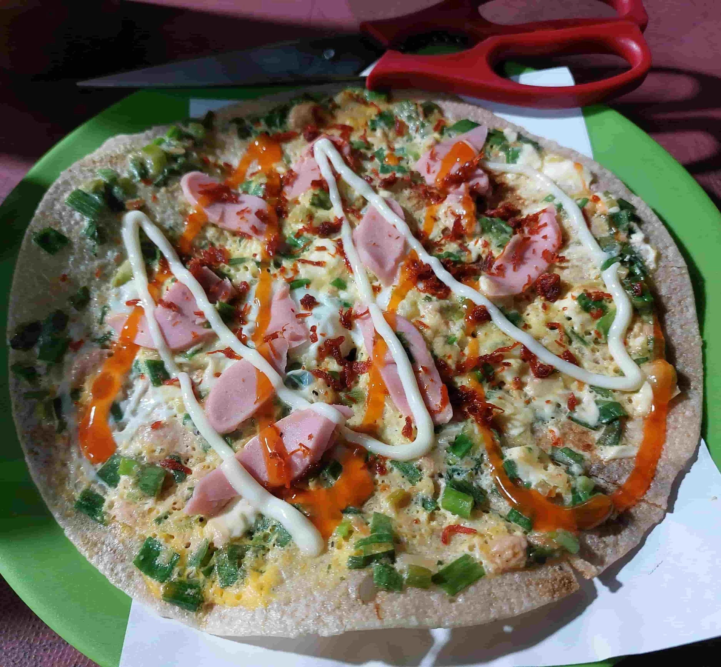 Bánh Tráng Nướng – Vietnamese grilled rice paper topped with egg, sausage, scallions, chili sauce, and mayonnaise