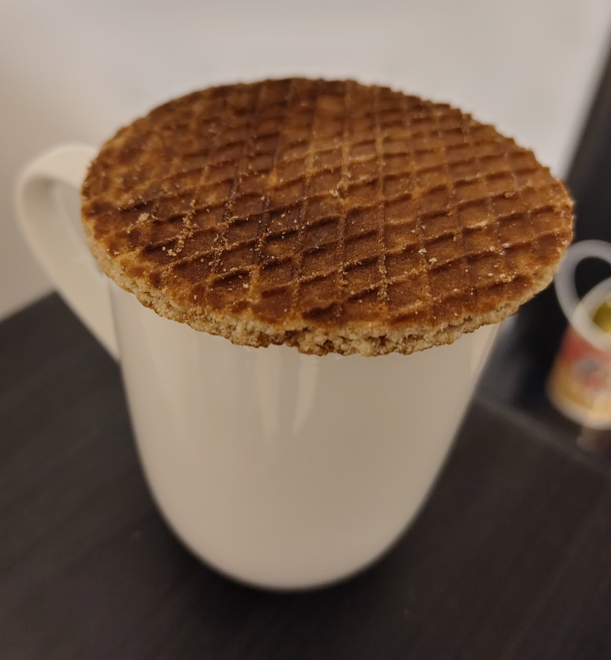 Dutch stroopwafel resting on a cup of hot coffee