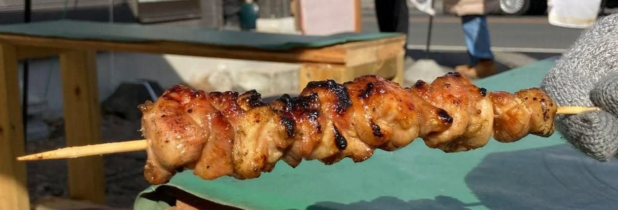 Japanese yakitori skewers grilled over charcoal, featuring glazed chicken