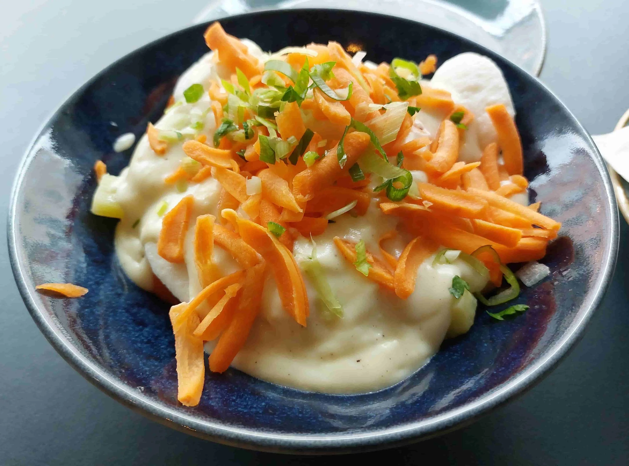 Norwegian fiskeboller i hvit saus – tender fish balls in a creamy white sauce, garnished with sliced carrots and chopped spring onions