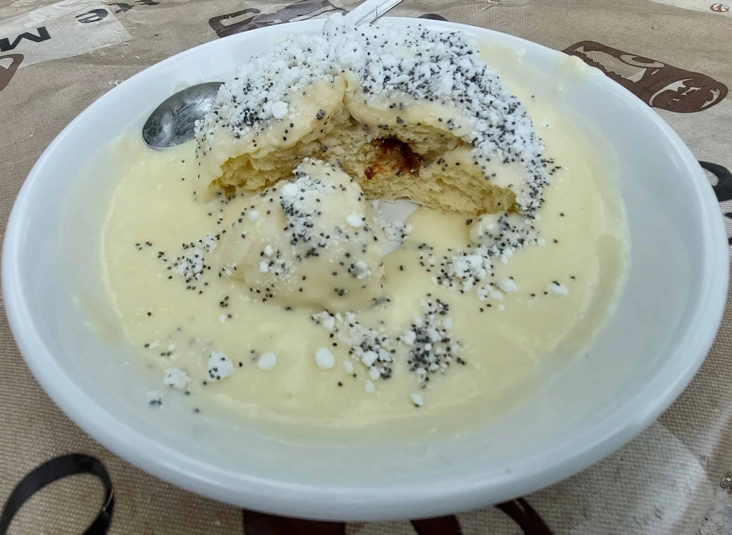 Austrian Germknödel yeast dumpling filled with plum jam topped with poppy seeds and vanilla sauce