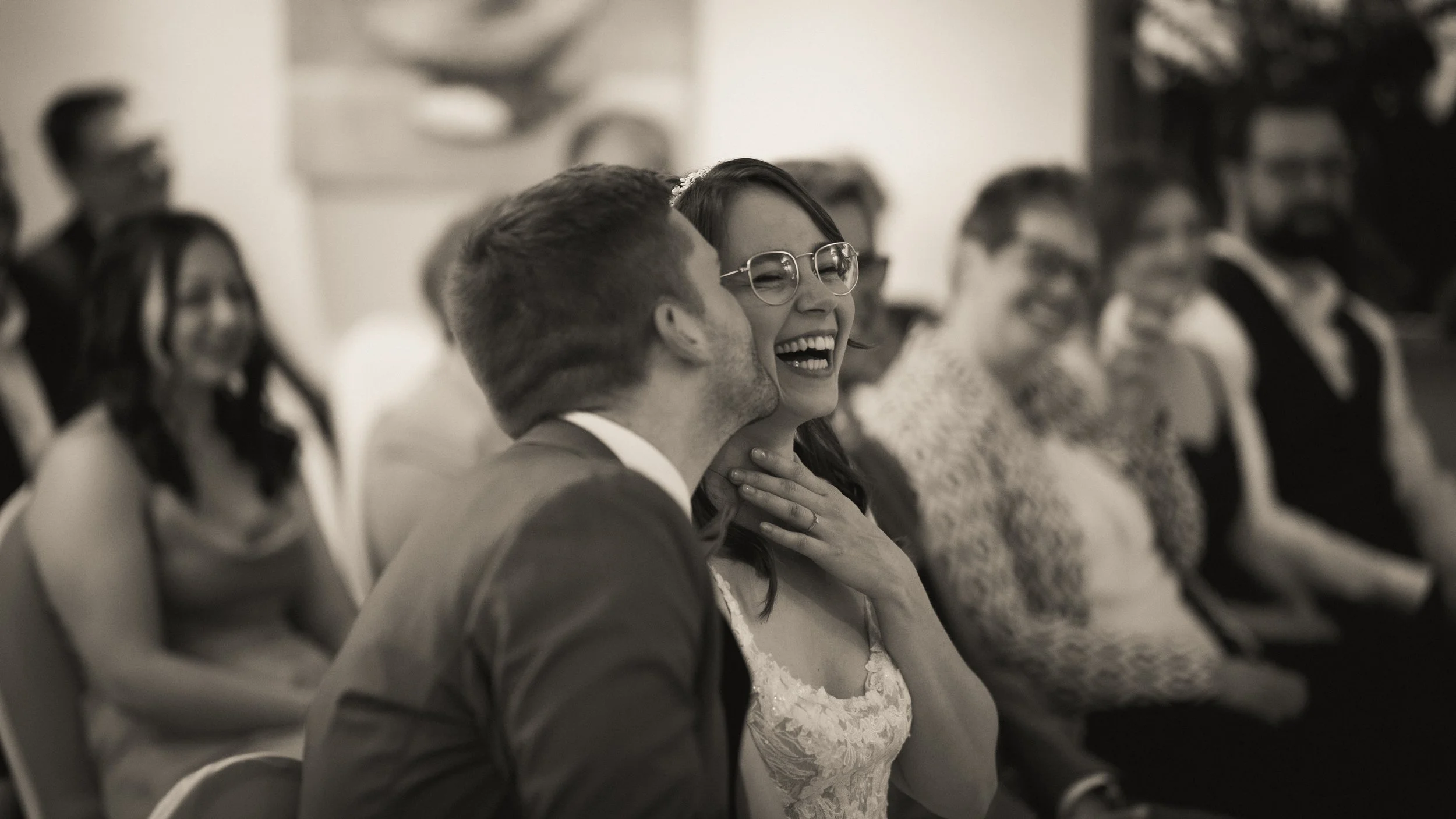 Menschen bei einer Hochzeitsfeier, lachend und in Gespräche vertieft, in einem festlichen Raum.