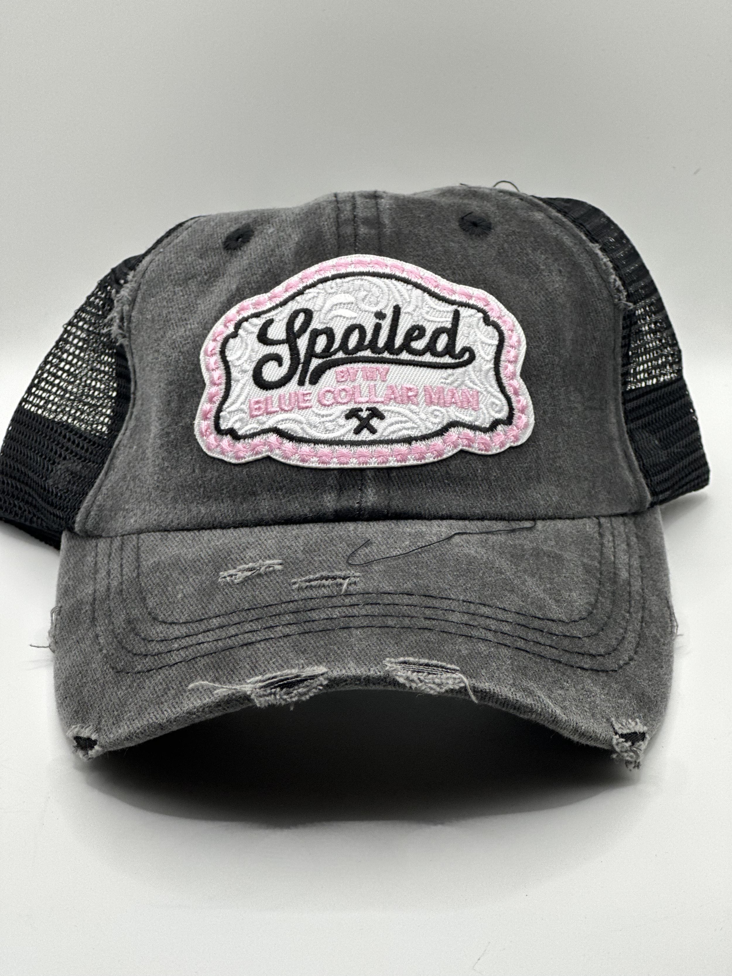 Gray distressed baseball cap with a white embroidered patch reading 'Spoiled' and 'Blue Collar Mom' in pink and black lettering, featuring mesh back panels.