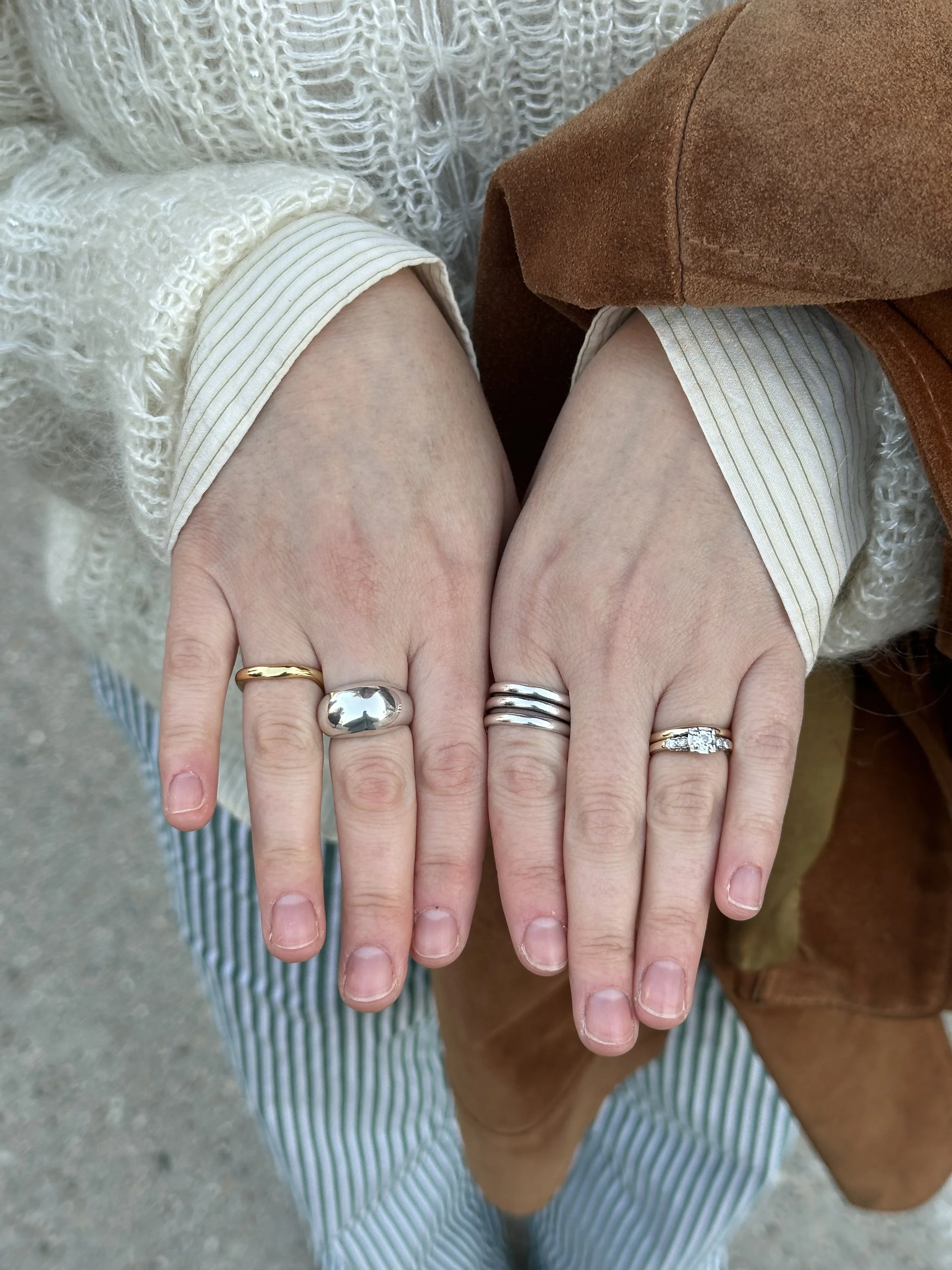 close-up of two hands wearing the handmade sterling silver reflection ring