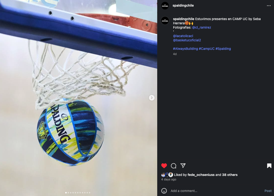 Balón de baloncesto en una pelota de Spalding colgando en una canasta de baloncesto por debajo del tablero.