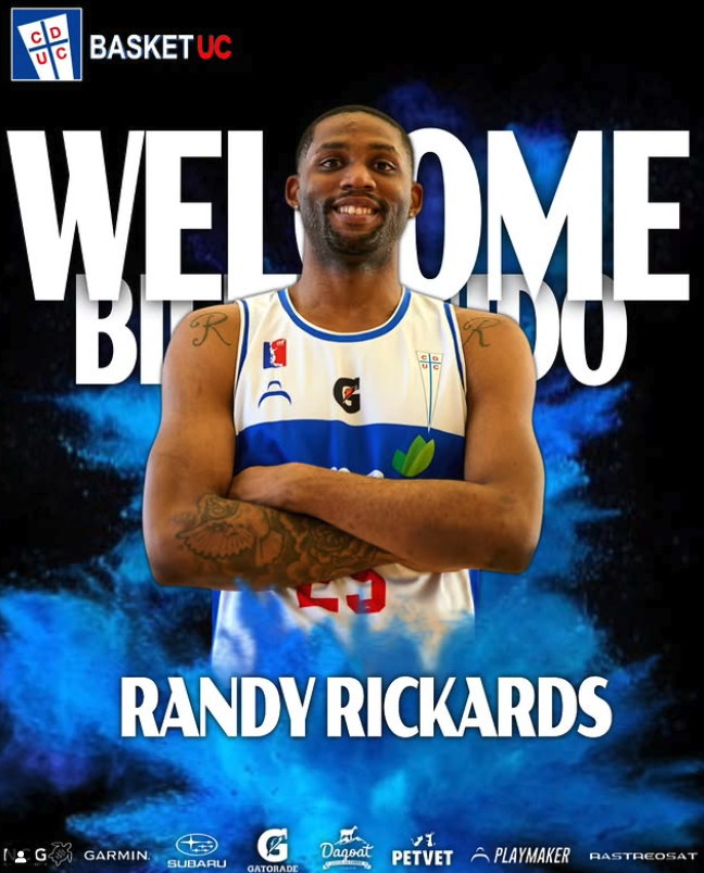 Jugador de baloncesto con camiseta del equipo UC, de brazos cruzados, sonriendo, en un fondo con texto que dice "Welcome" y el nombre "Randy Rickards".