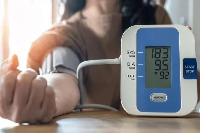 A person checking their blood pressure with a digital monitor