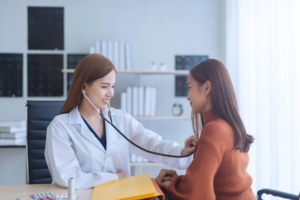 A doctor listening to a patient’s heartbeat