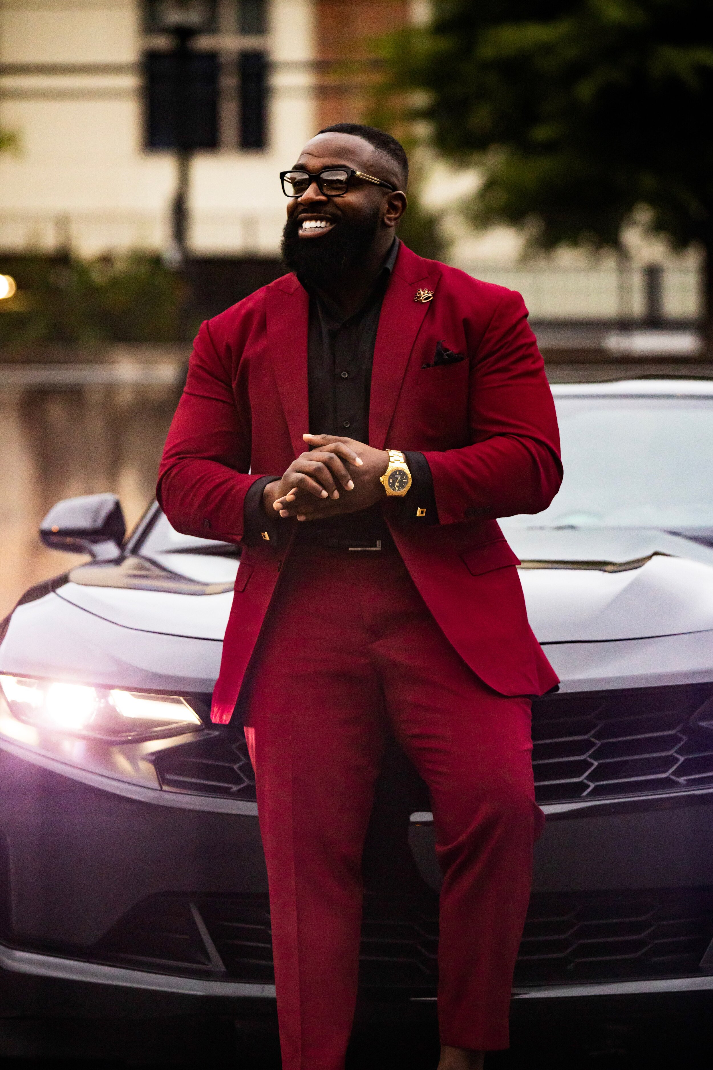 New business photoshoot featuring a client in a burgundy wine suit with black accents for a sleek, formal look. This photoshoot was designed for a book release and business venture, highlighting professionalism, class, and personality. The stylish ou