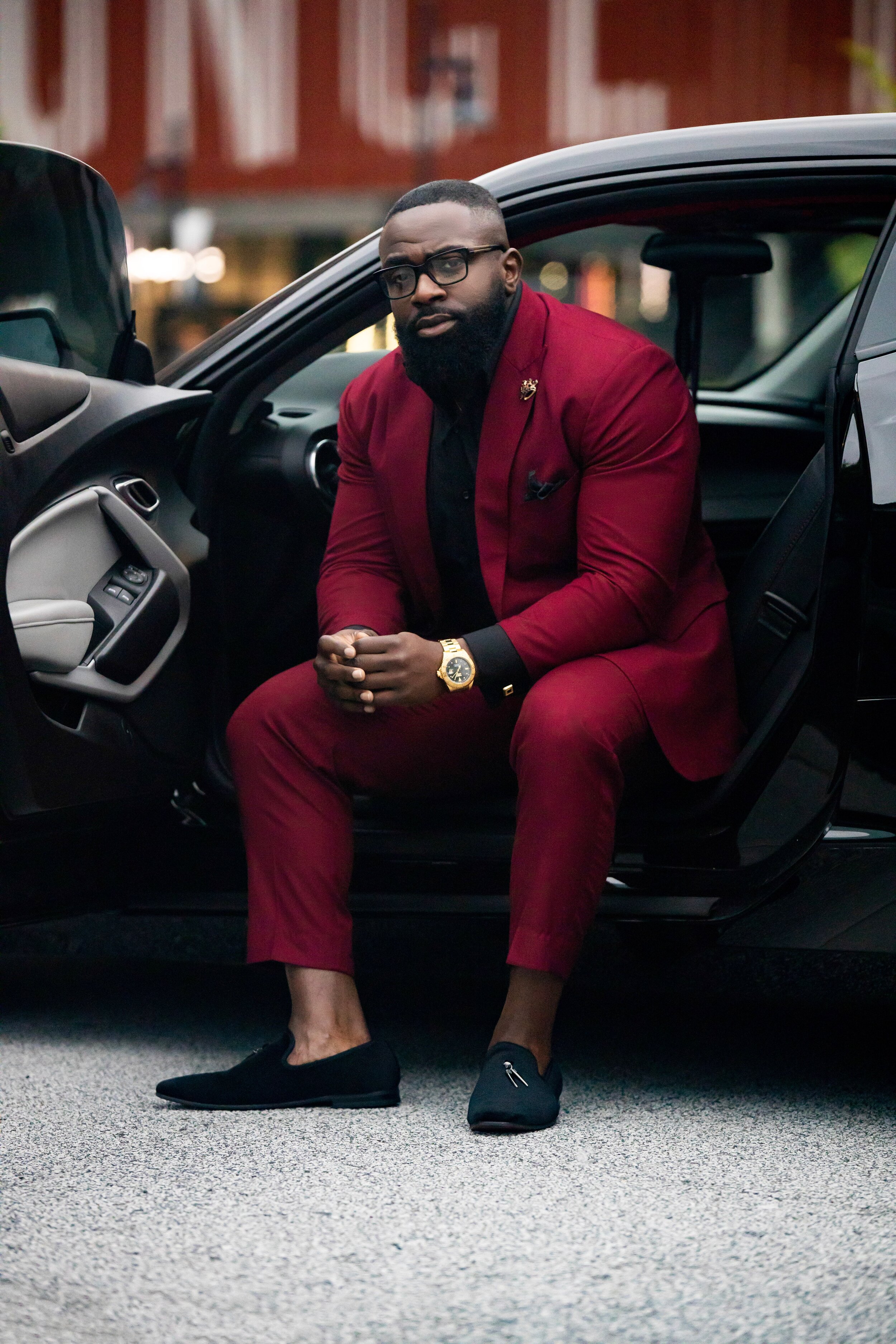 New business photoshoot featuring a client in a burgundy wine suit with black accents for a sleek, formal look. This photoshoot was designed for a book release and business venture, highlighting professionalism, class, and personality. The stylish ou