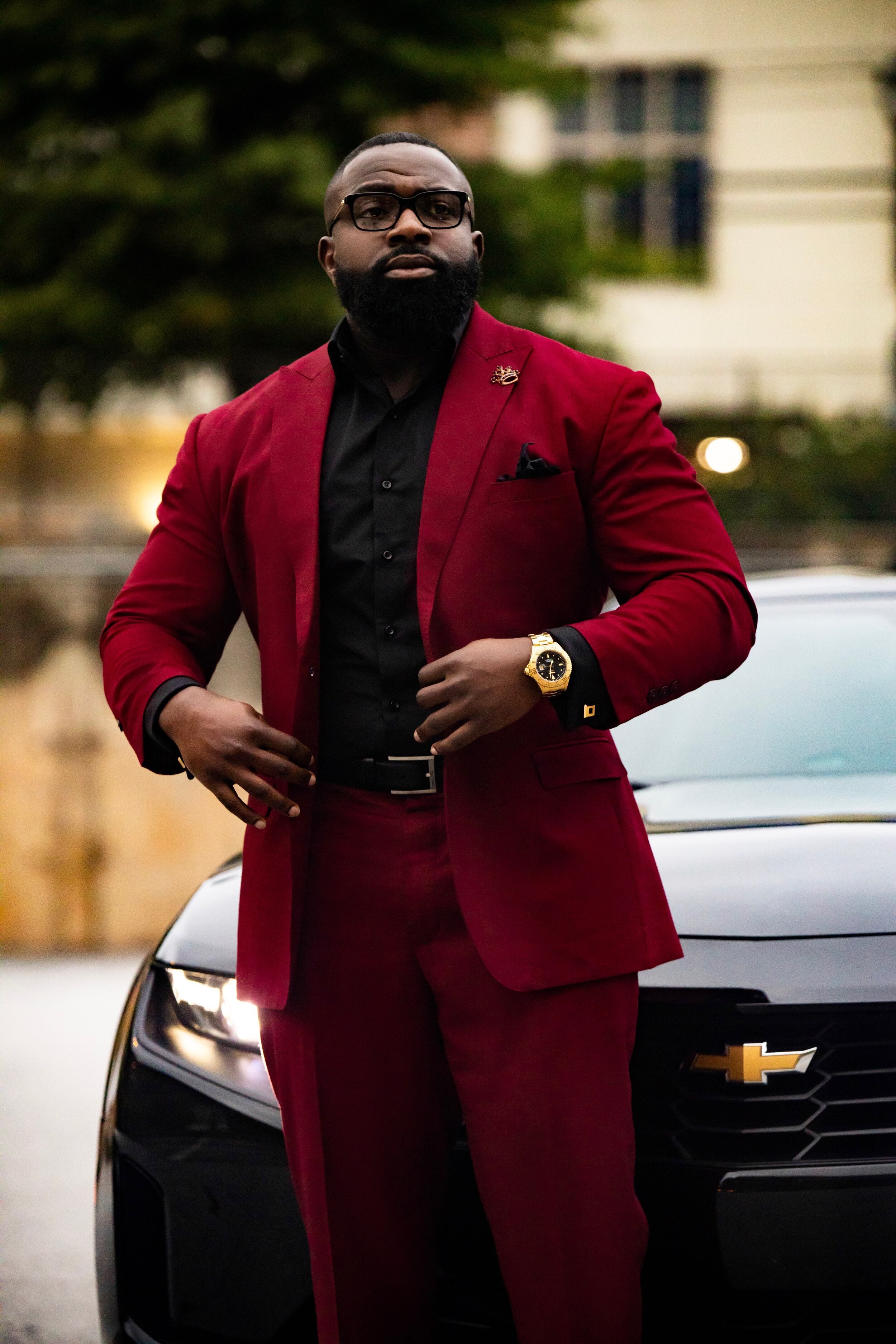 New business photoshoot featuring a client in a burgundy wine suit with black accents for a sleek, formal look. This photoshoot was designed for a book release and business venture, highlighting professionalism, class, and personality. The stylish ou