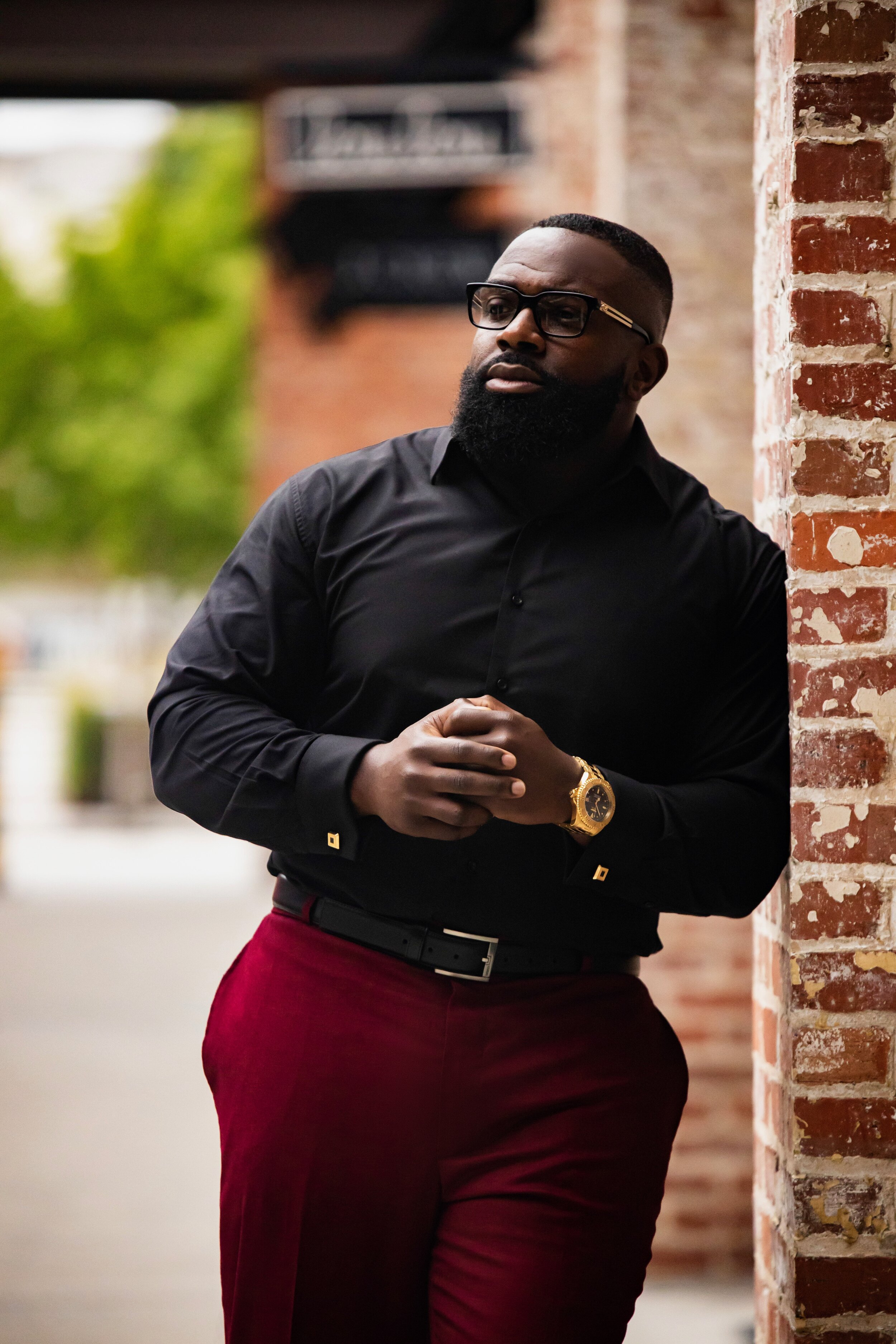 New business photoshoot featuring a client in a burgundy wine suit with black accents for a sleek, formal look. This photoshoot was designed for a book release and business venture, highlighting professionalism, class, and personality. The stylish ou