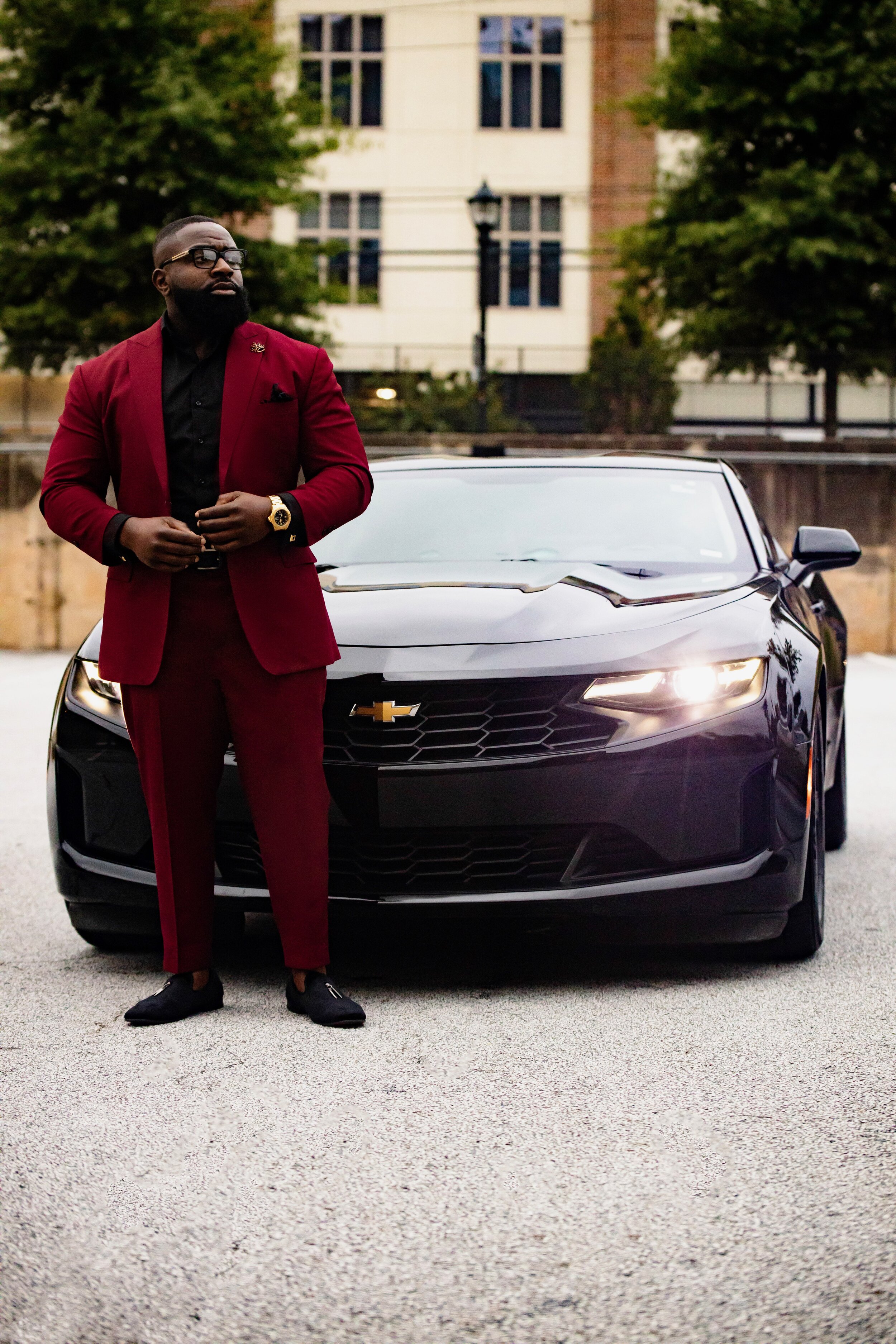New business photoshoot featuring a client in a burgundy wine suit with black accents for a sleek, formal look. This photoshoot was designed for a book release and business venture, highlighting professionalism, class, and personality. The stylish ou
