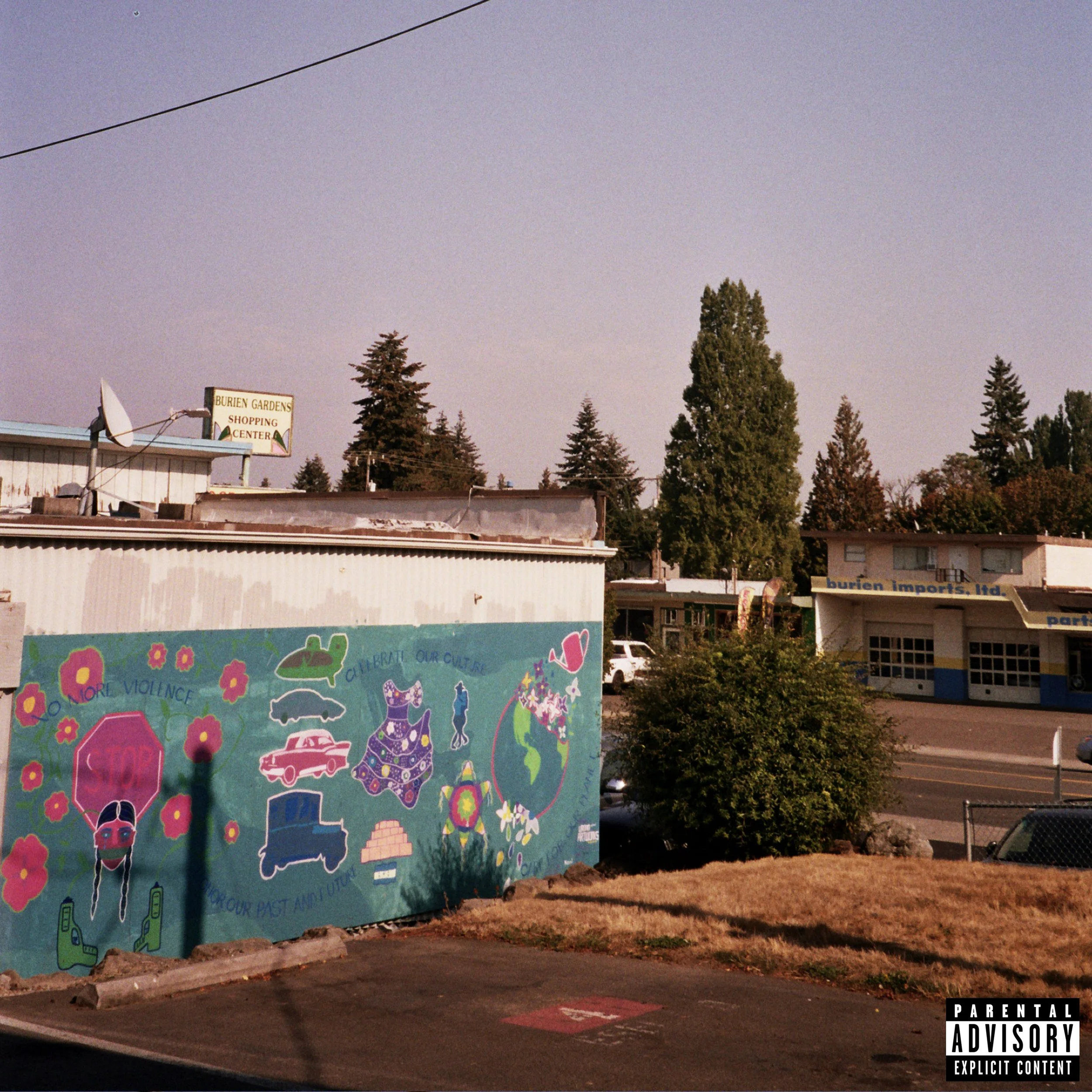 A mural on a wall featuring various illustrations and text advocating to end violence and celebrate culture, with trees and buildings in the background.