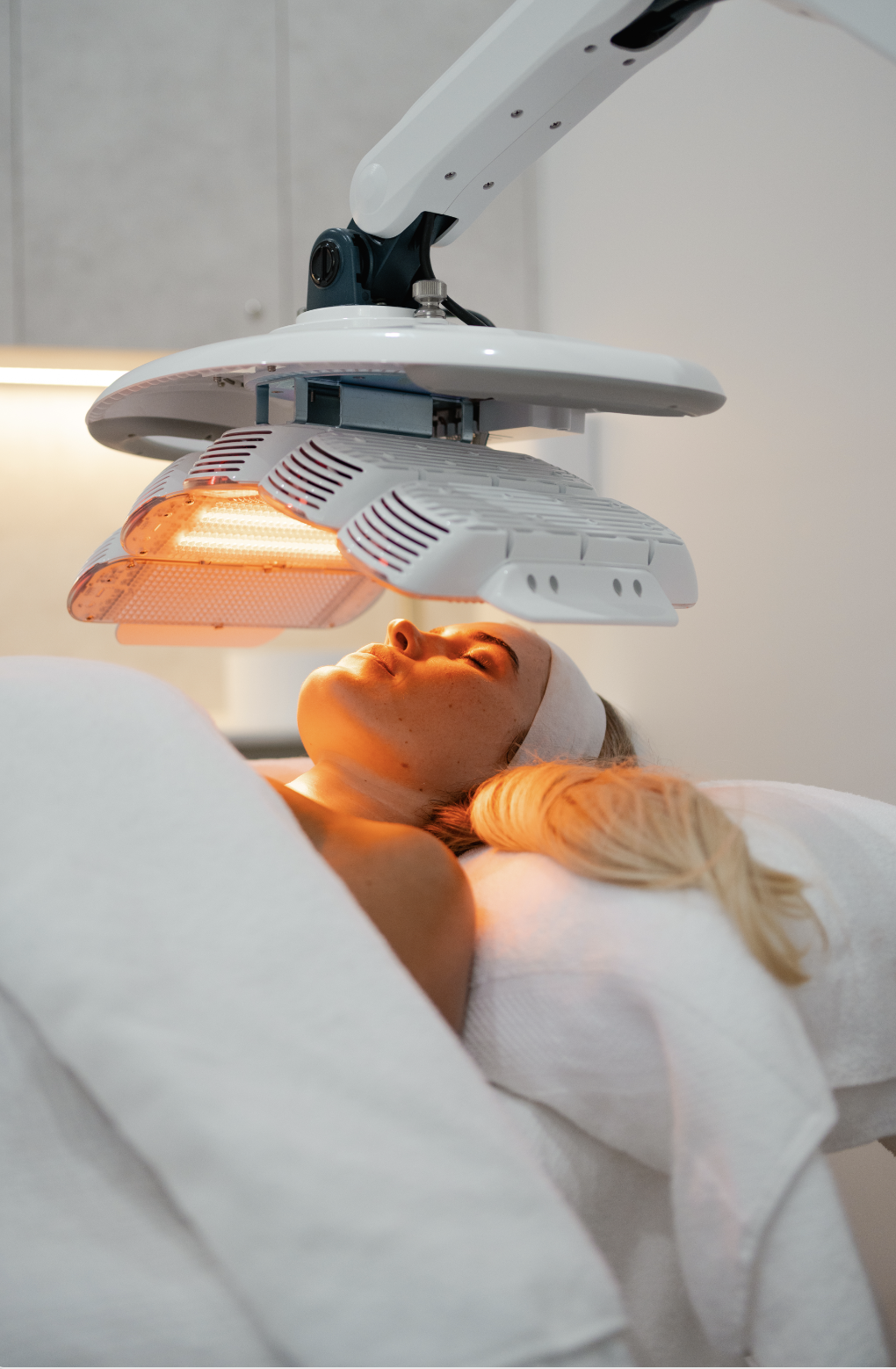 A person receiving LED light therapy on their face in a spa setting.